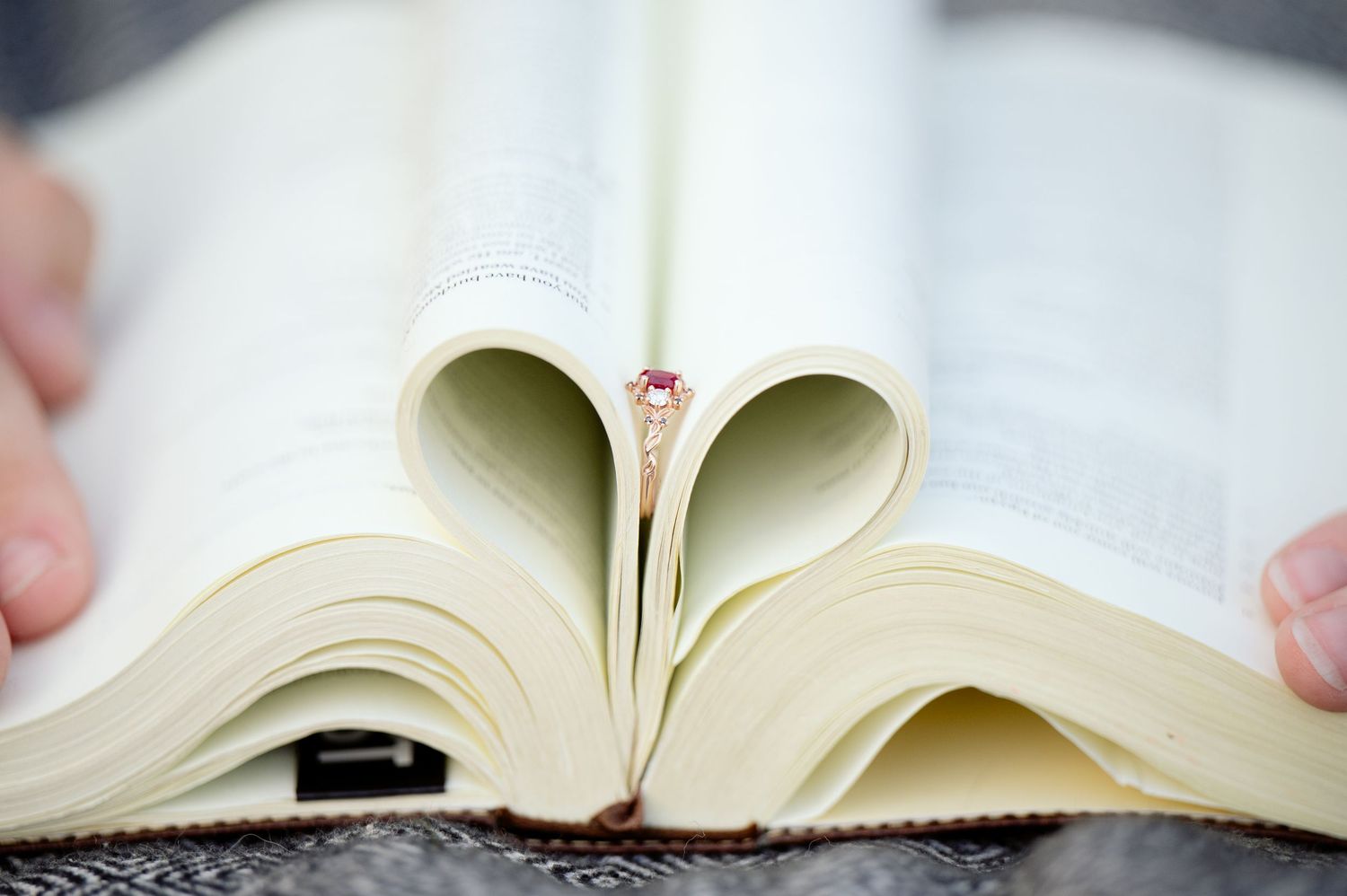 A sequence of four overlapping images showing open books with pages splayed and folded against light backgrounds.