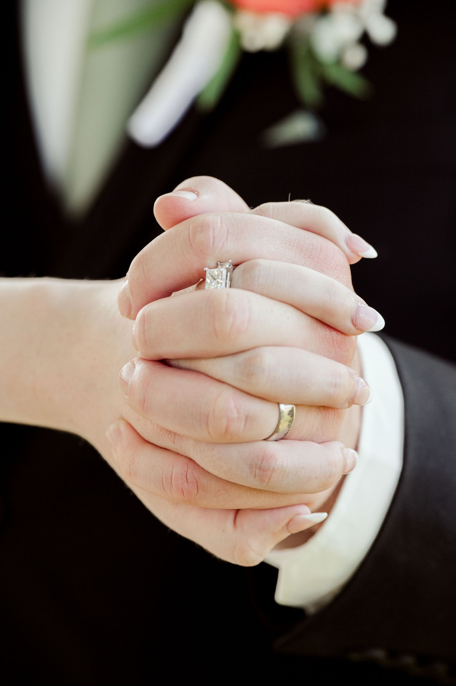 The Grands At Mulligans. Close-up views of hands holding and showcasing a sparkling engagement ring.