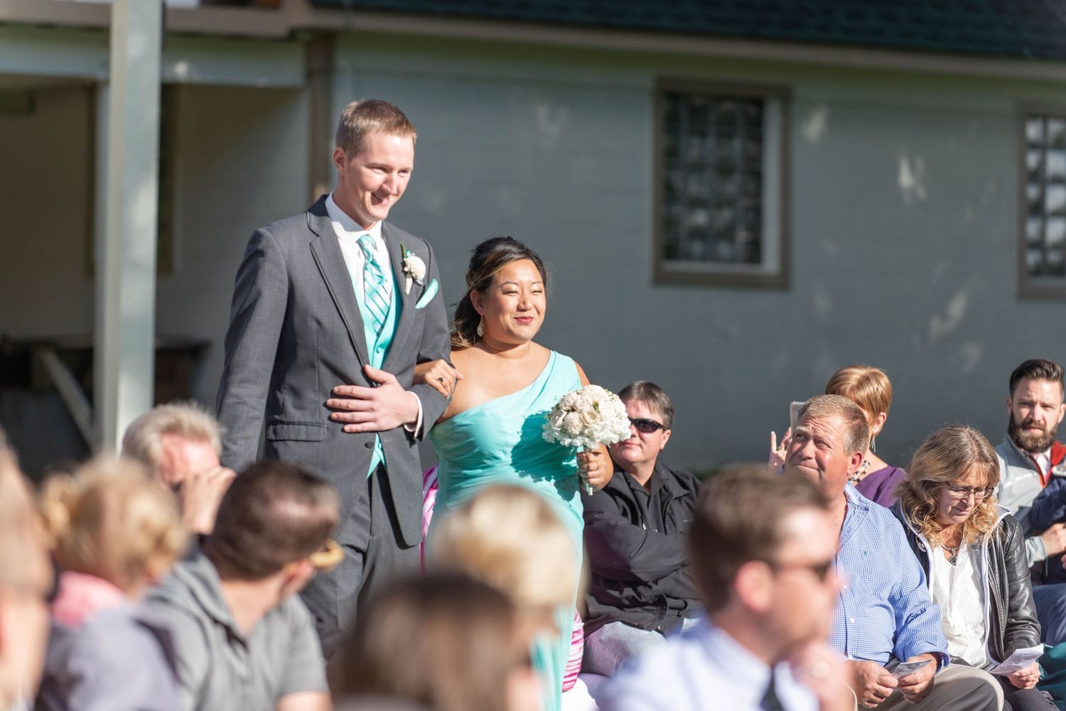 Wedding guests seated outdoors watching ceremony proceedings. Rum River Barn Milaca Minnesota Weddings