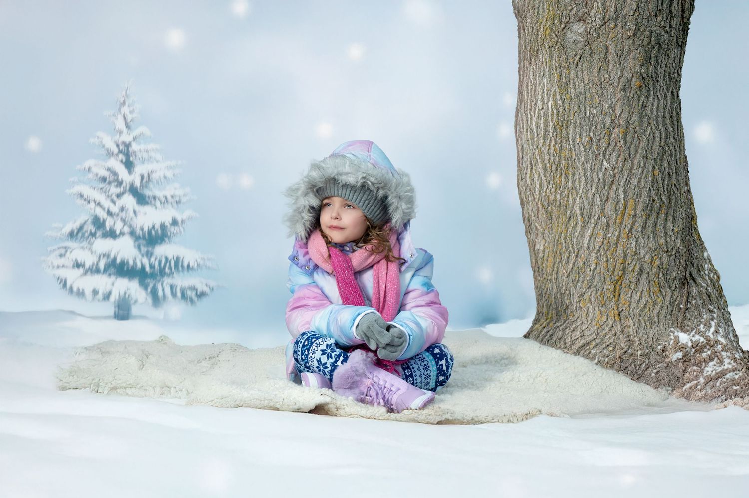 Winter landscape with someone resting in snow beside a tree during a snowy day.