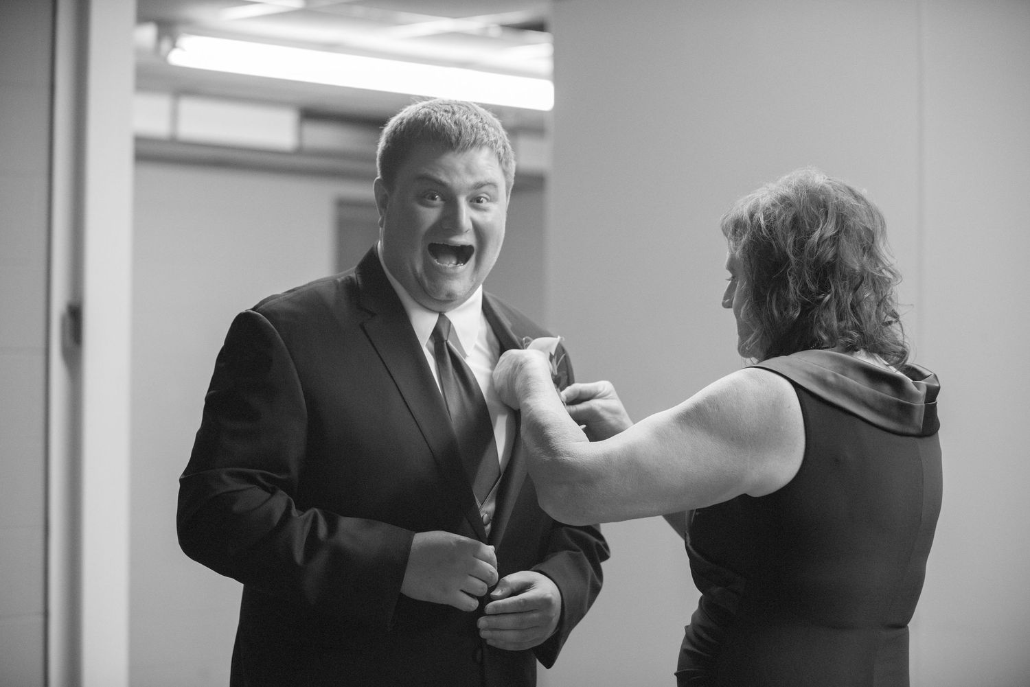 Wedding party interacting with expressions of joy and laughter at indoor reception. Andover wedding at Magestic Oaks Golf Club
