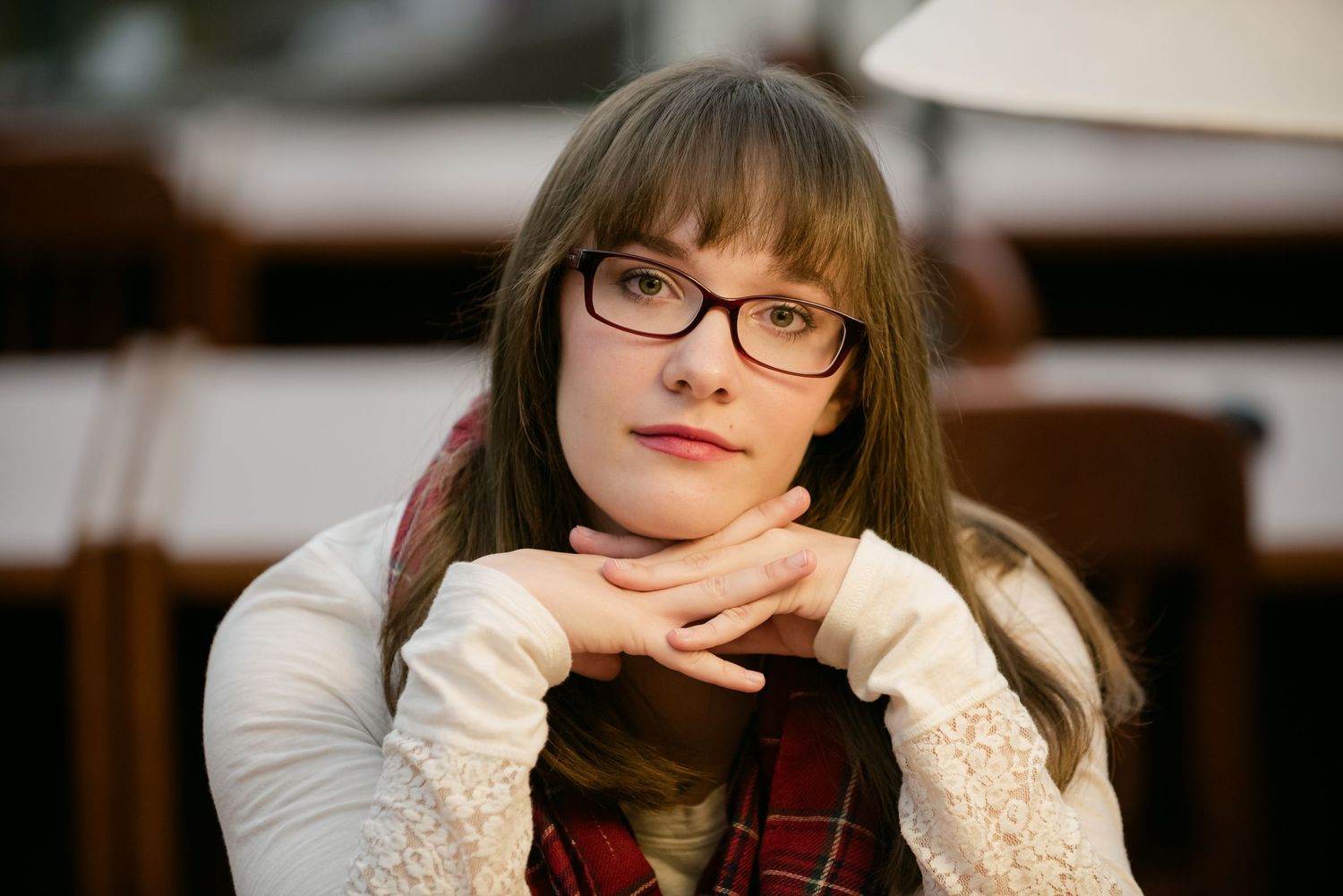 Senior Portrait at St Cloud State A close-up portrait of someone wearing glasses and a white sweater looking contemplatively to the side.