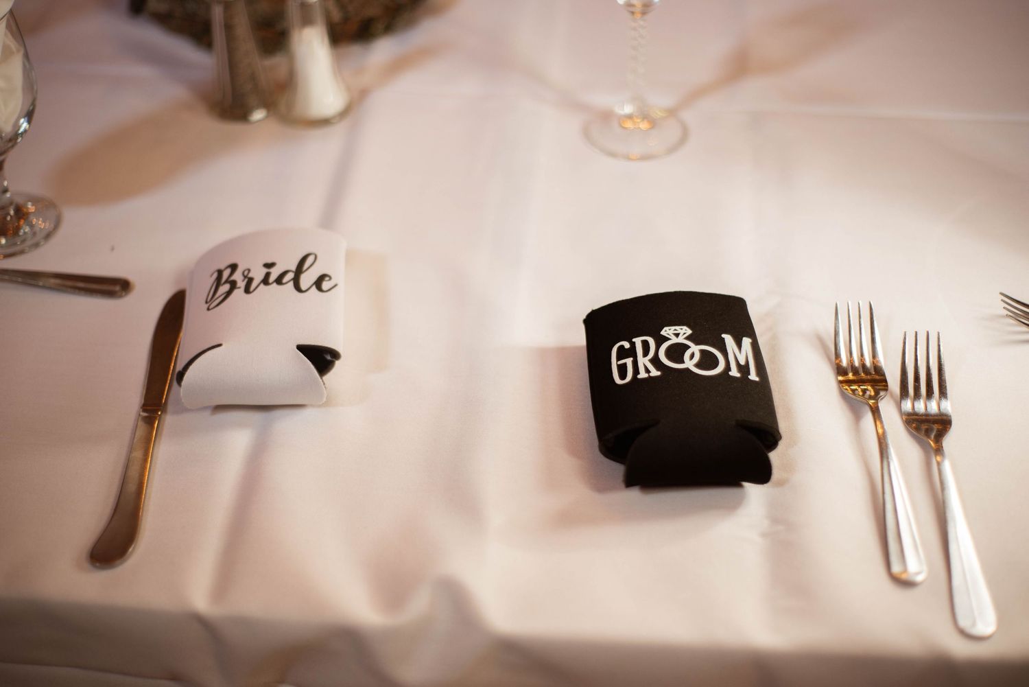 Beautiful wedding reception table decor featuring personalized name cards, stylish white linens and elegant place settings.