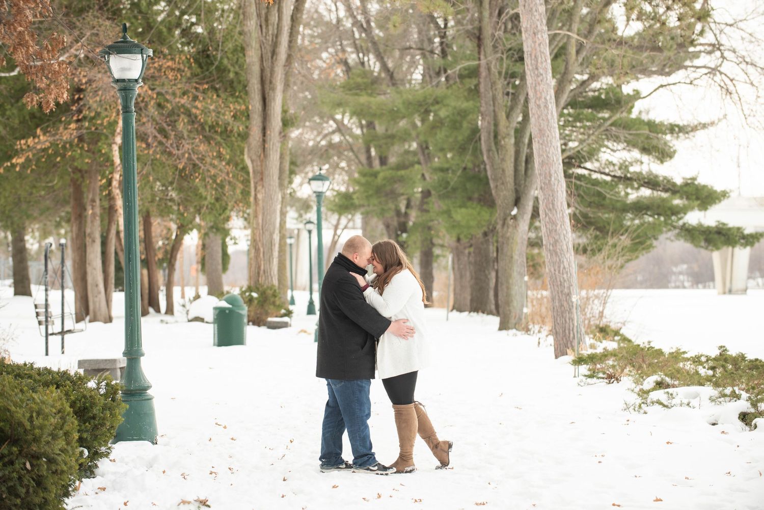 A series of winter engagement photos showing people walking and embracing in a snowy outdoor setting.