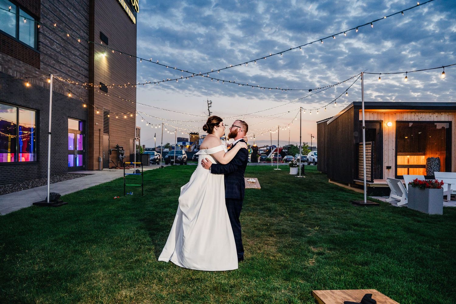 Pier B Duluth Wedding Evening wedding portraits with industrial cityscape backdrop and string lights overhead.