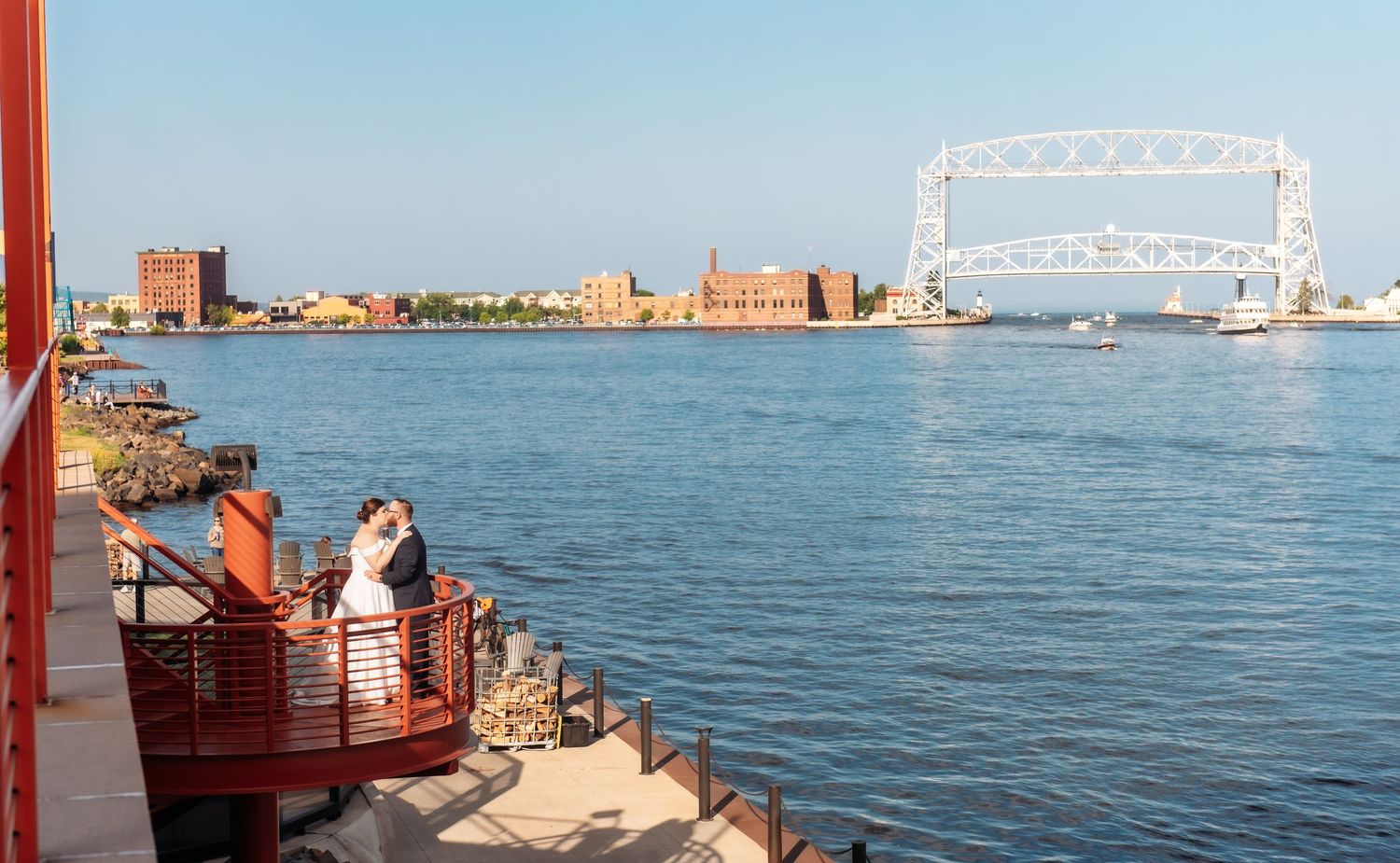 View of Duluth harbor with iconic Aerial Lift Bridge and industrial waterfront seen from red lighthouse stairs.