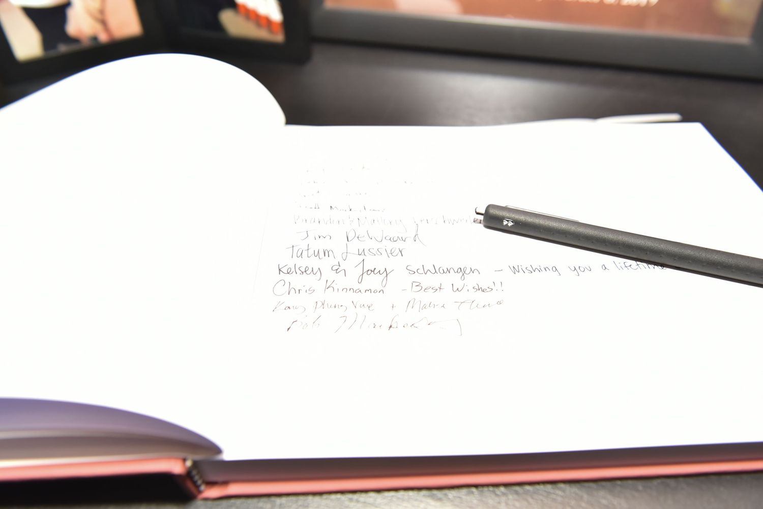 Guest book and signing materials displayed on table at wedding reception.