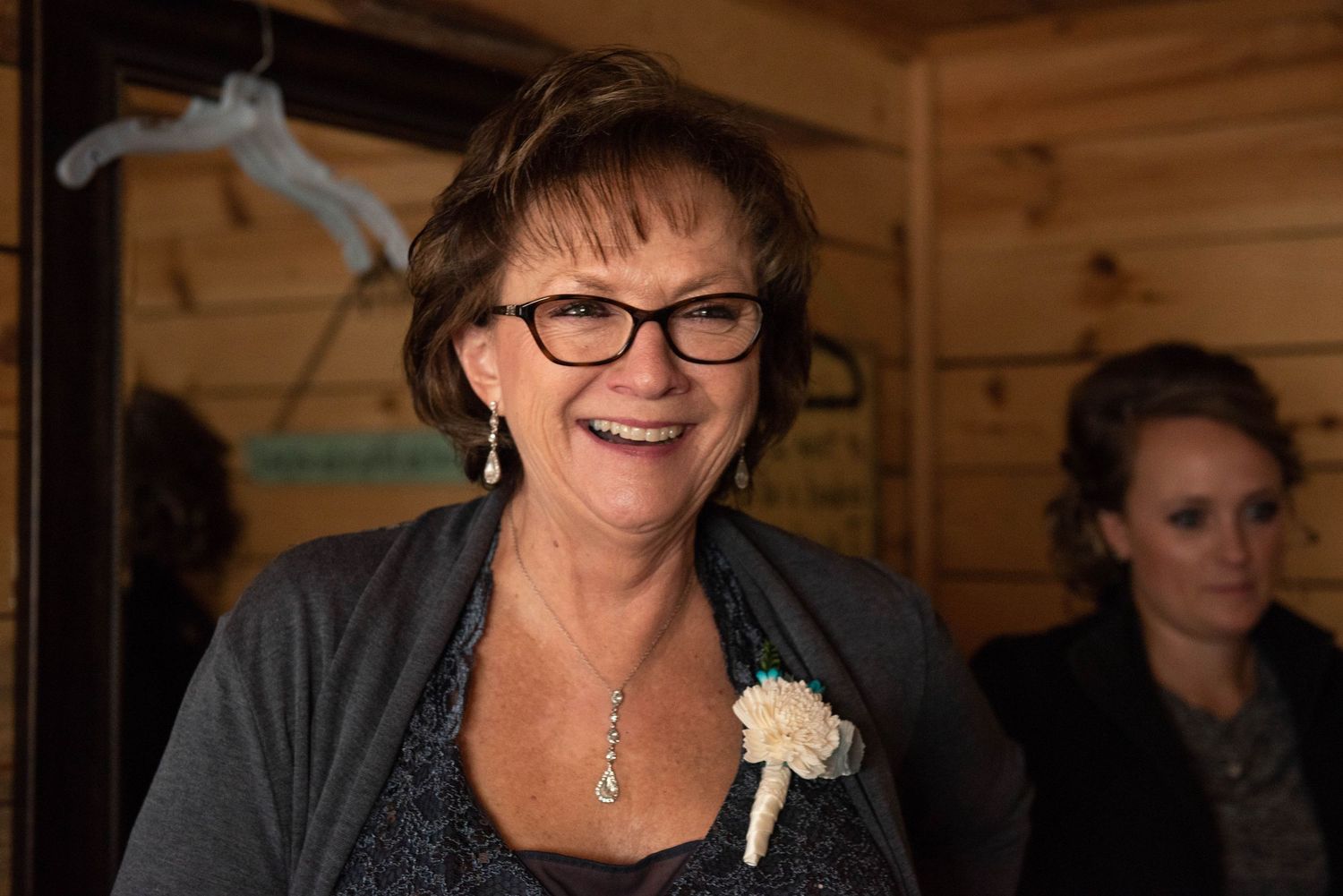 A joyful moment captured during wedding preparations in a rustic wooden interior. Rum River Barn Milaca Minnesota Weddings