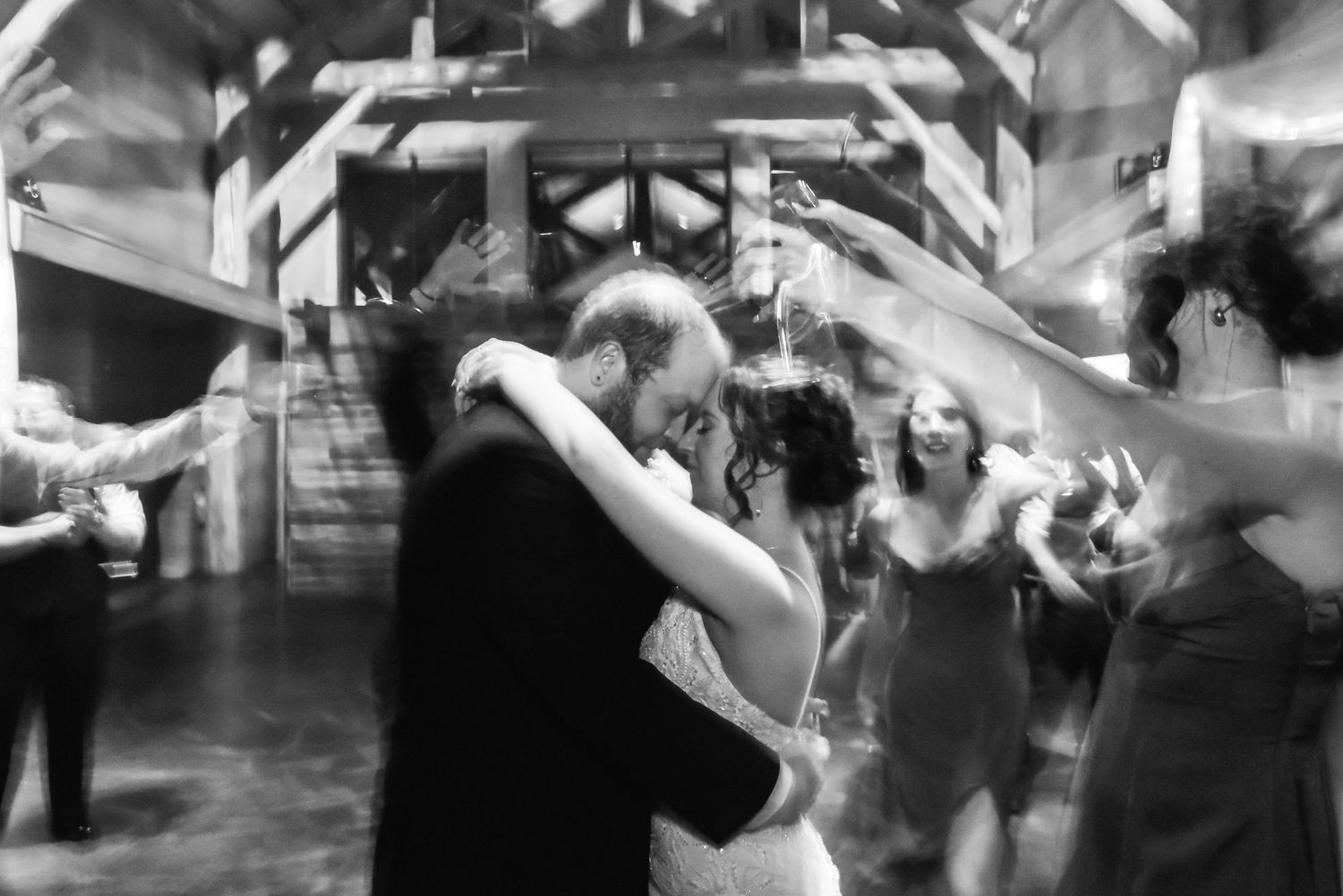 The Grands at Mulligans- Wedding Photos: Black and white photo of people dancing and celebrating during a wedding reception.