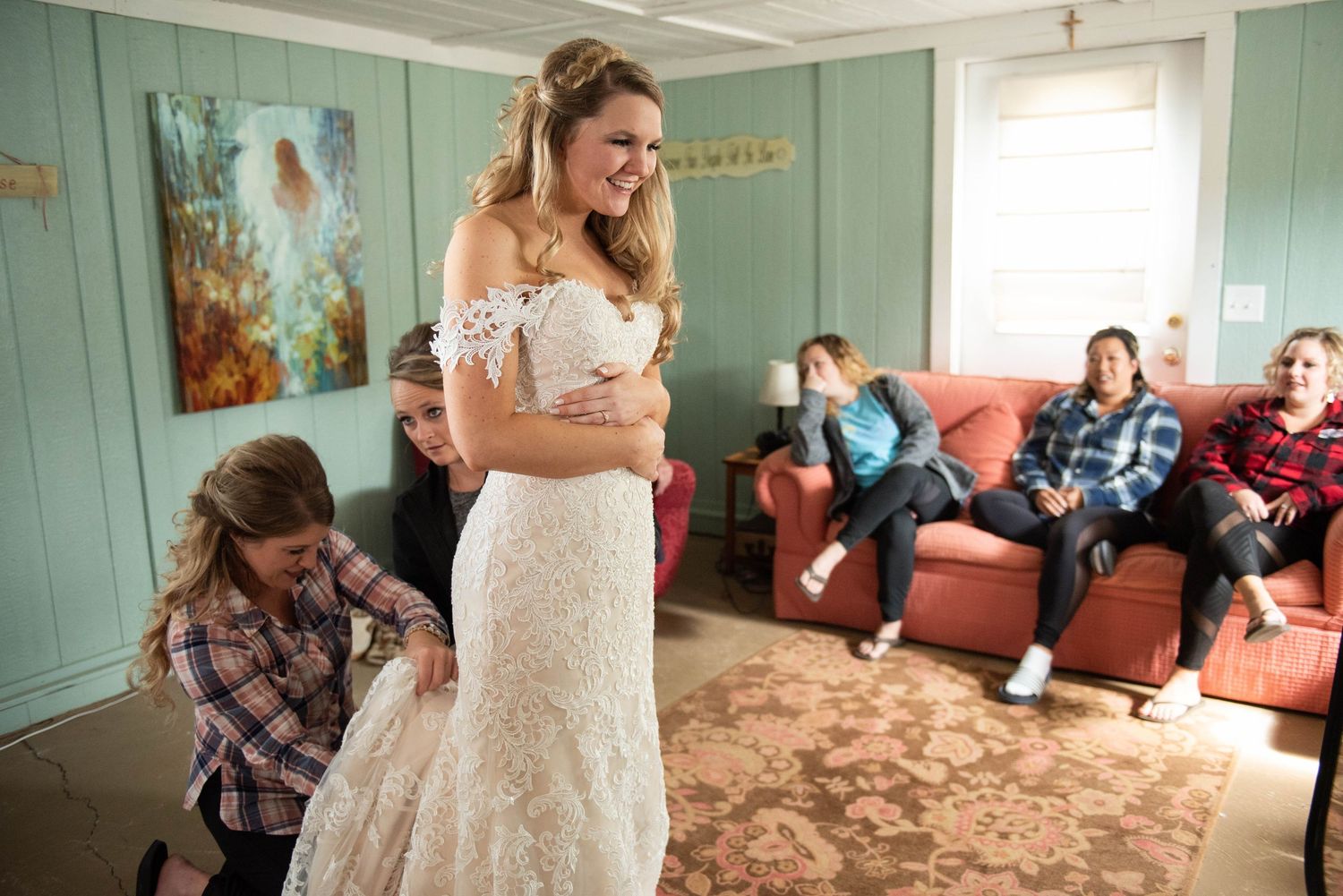 Final wedding dress adjustments being made in a room with mint green walls.