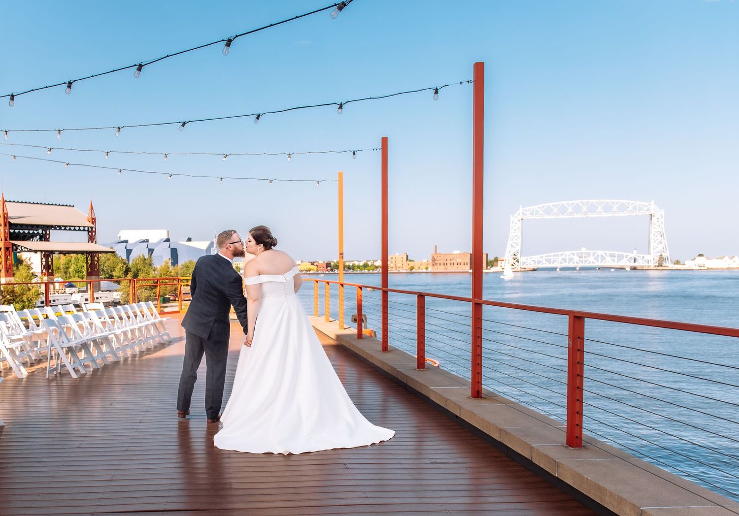 Peir B Wedding in Duluth Minnesota. Couple on the balcony with the lift bridge in the distance.