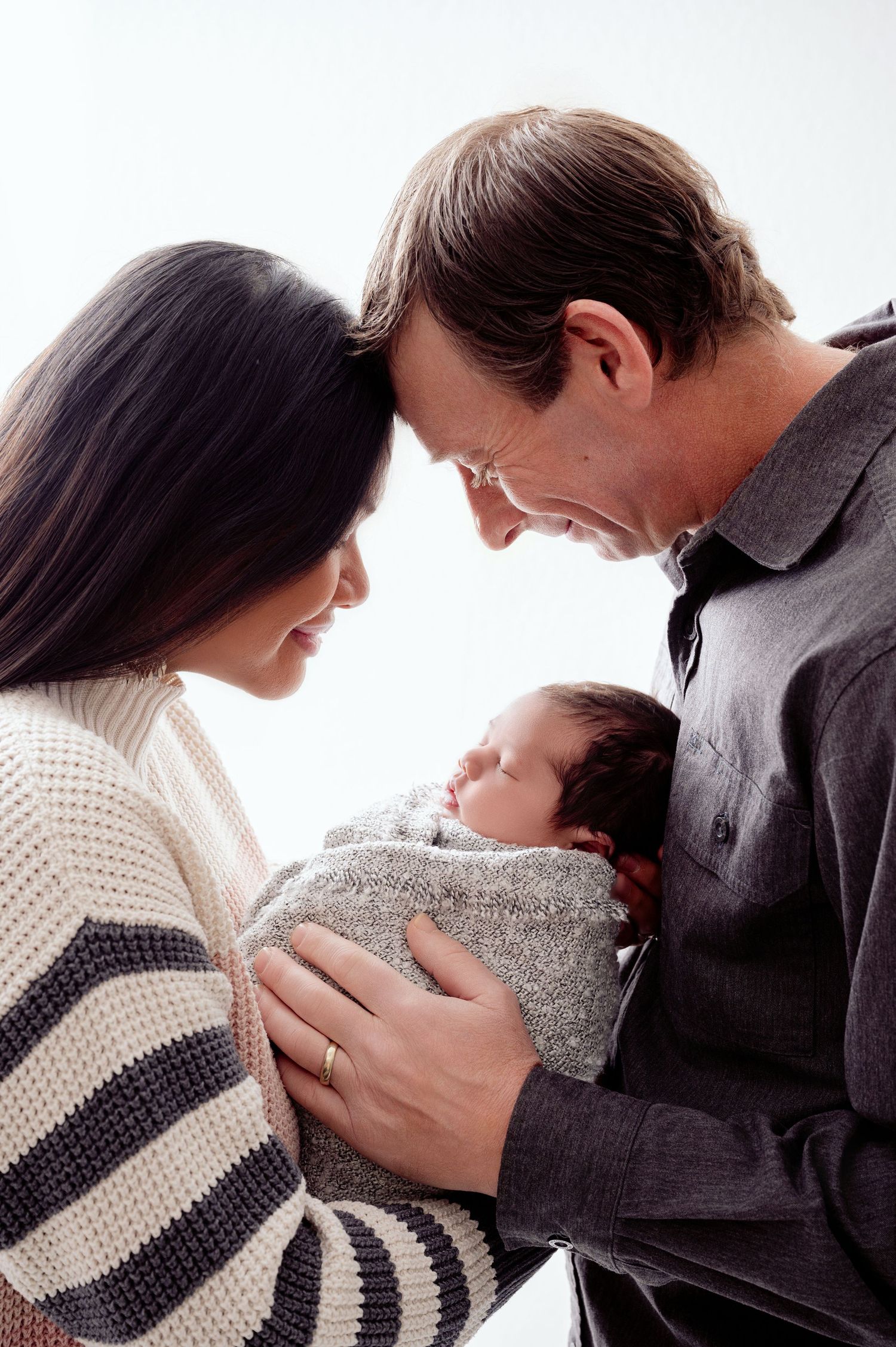 A sequence of intimate romantic moments between a couple wearing cozy sweaters against a white background.