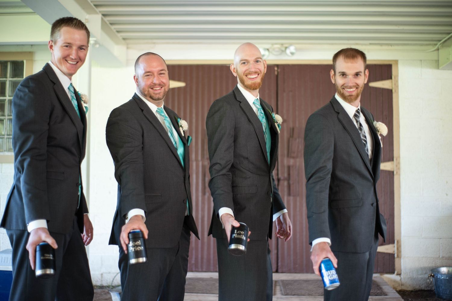 Groomsmen playfully adjust their ties in a coordinated lineup on the wedding day.