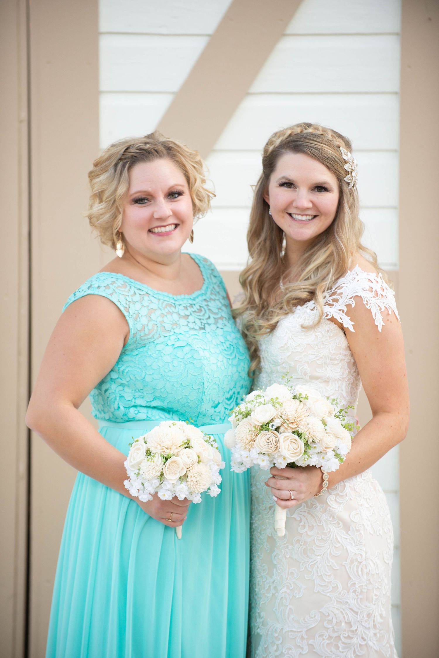 Two women in mint and white dresses pose with matching white bouquets. Milaca Minnesota Weddings