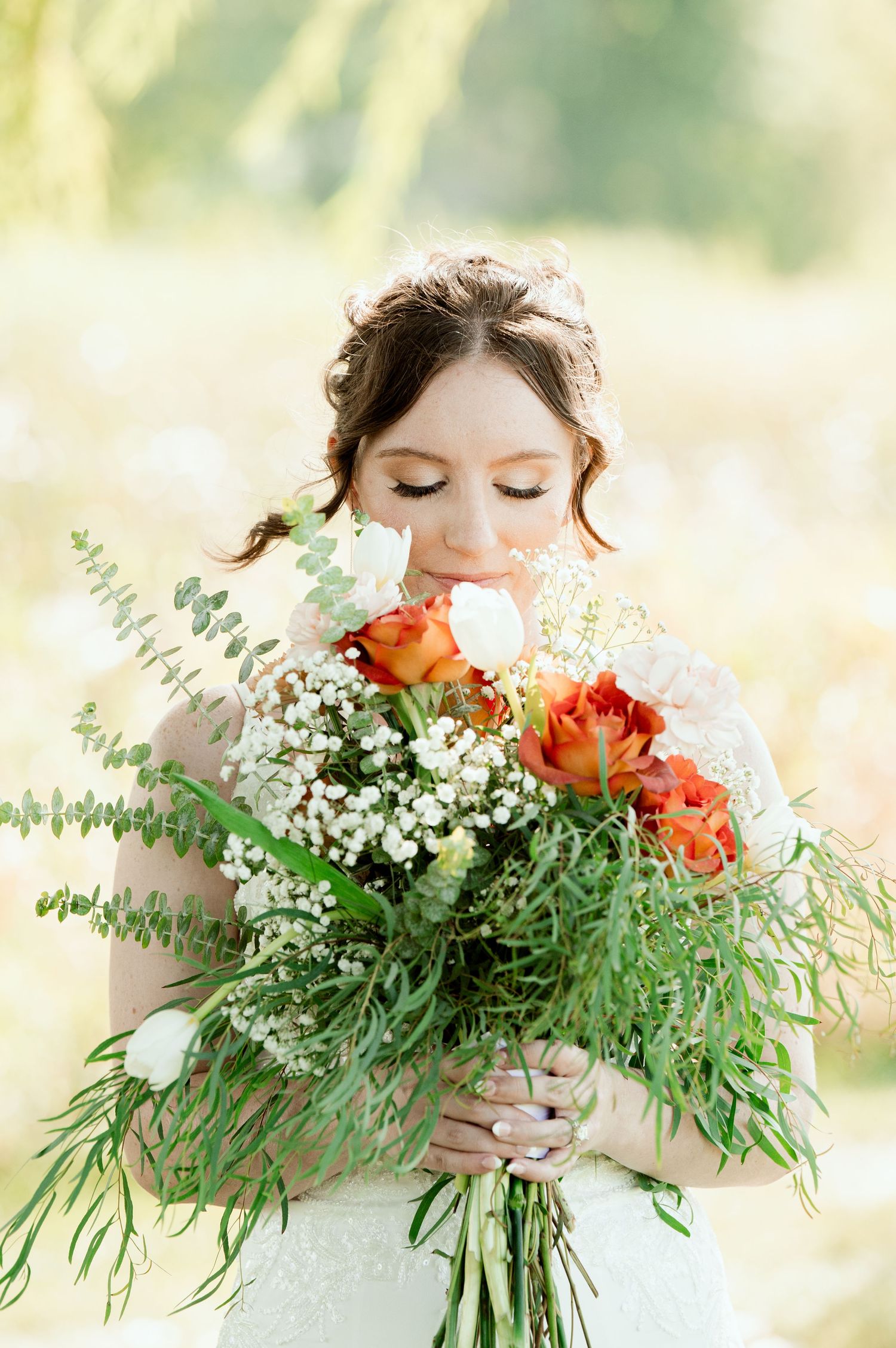 The Grands at Mulligans- Wedding Photos: romantic showing a bride holding a lush bouquet of coral roses and white baby's breath.
