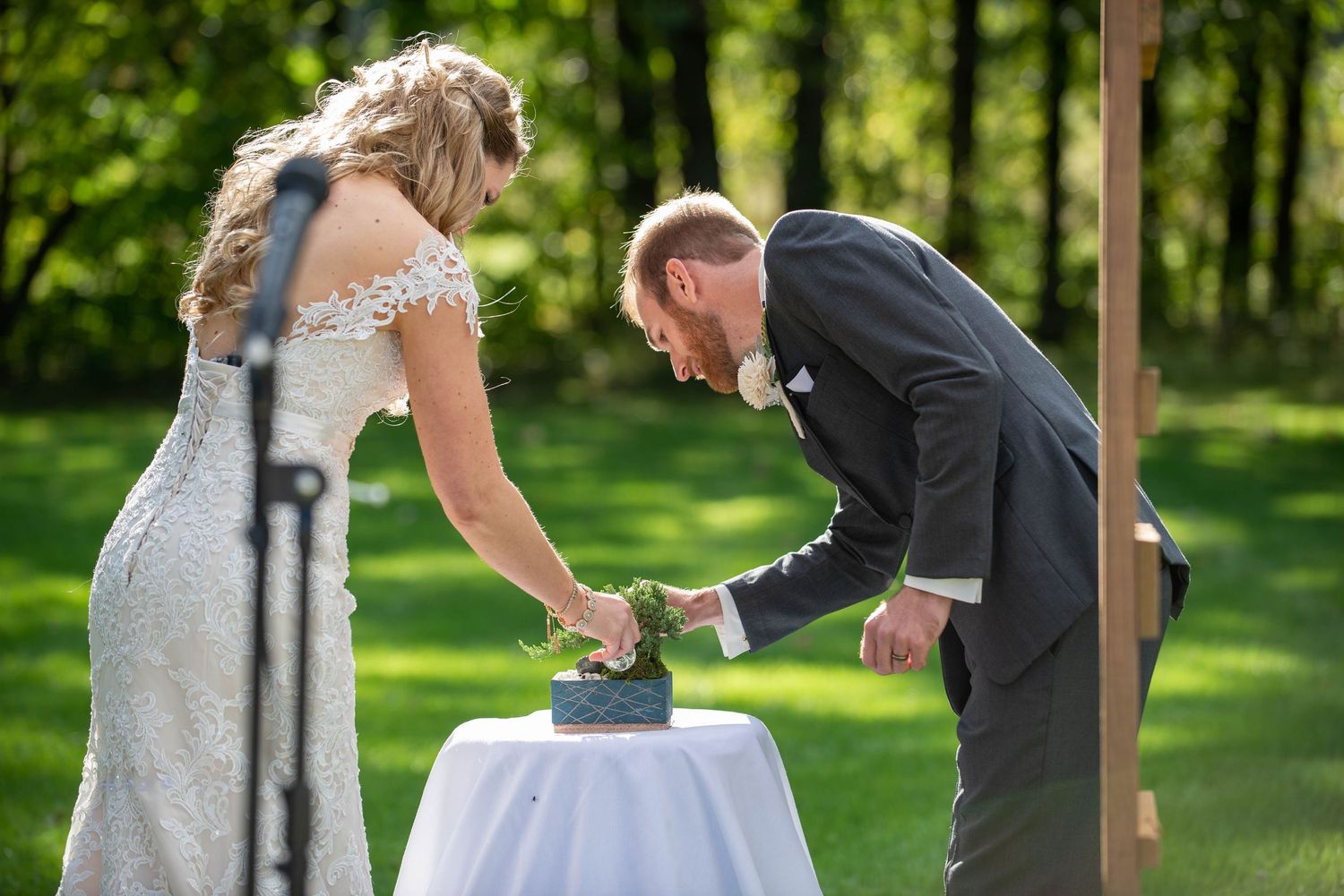 A couple performs a unity ceremony ritual at their outdoor wedding. Rum River Barn Milaca Minnesota Weddings