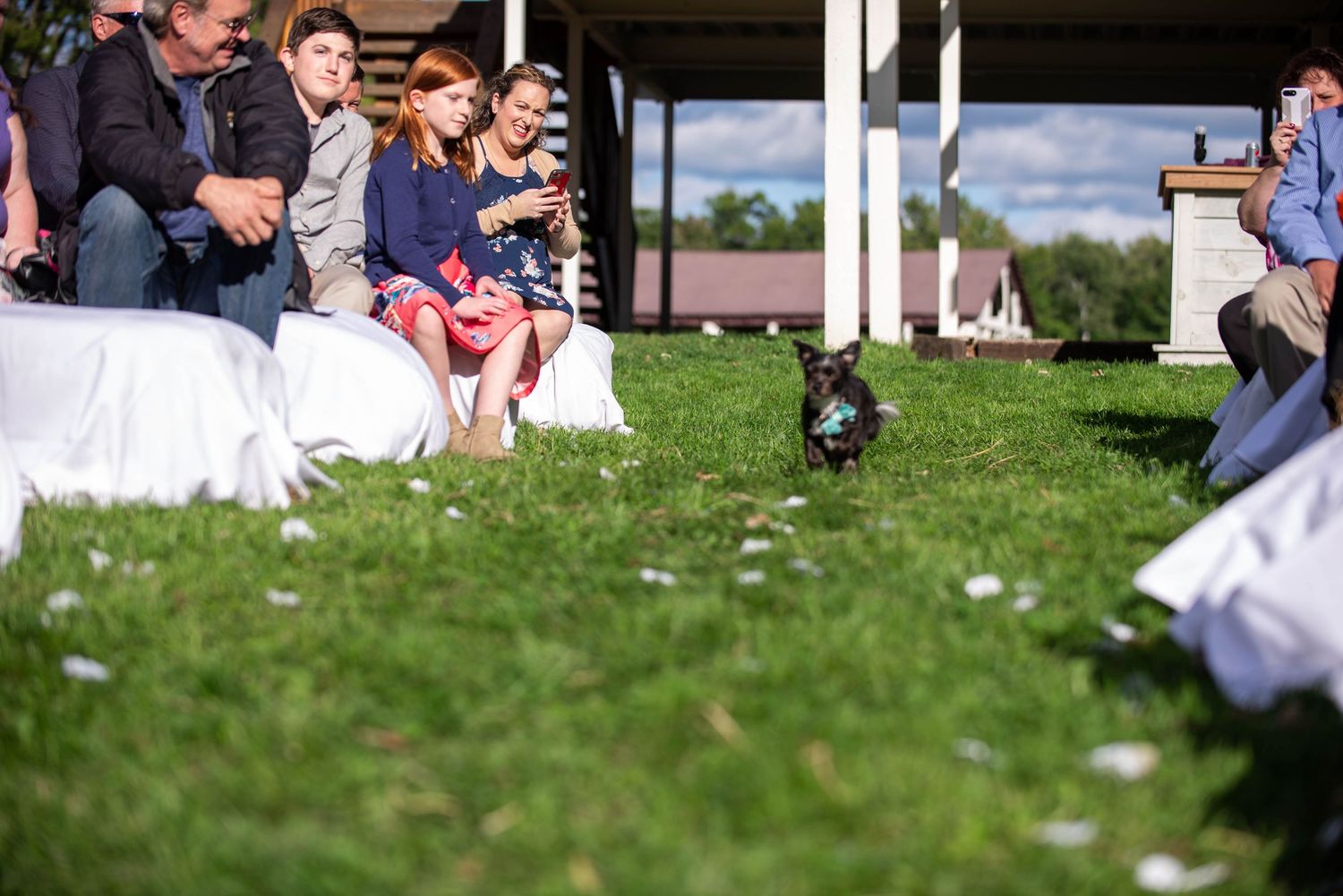 Wedding guests seated on white chairs during an outdoor garden ceremony. Rum River Barn Milaca Minnesota Weddings