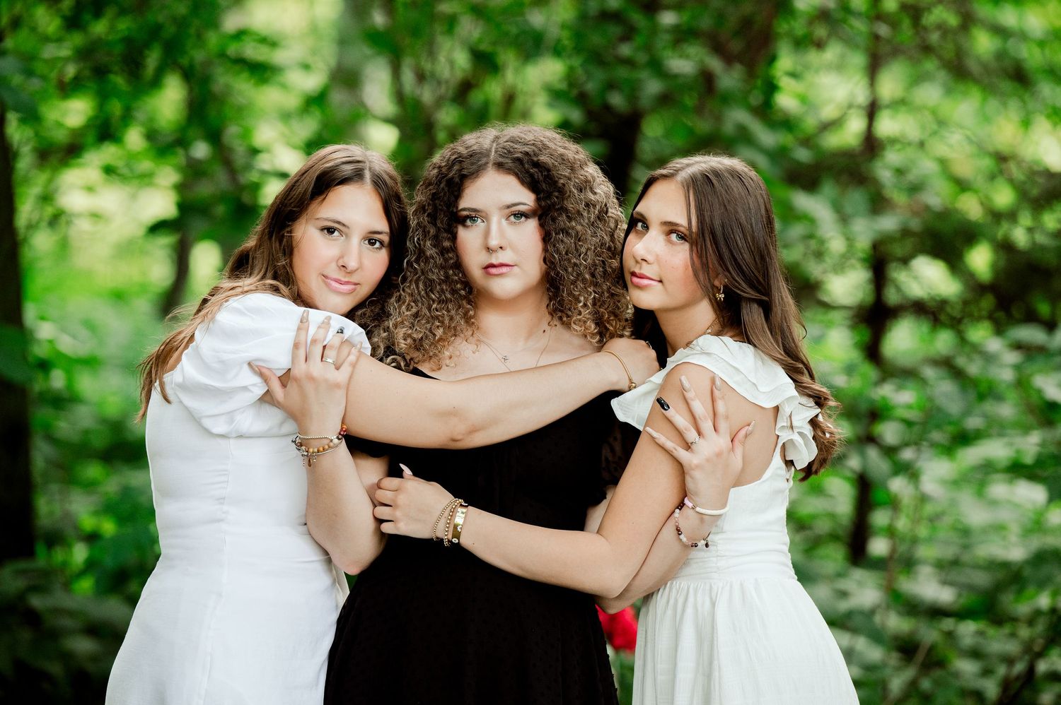 Clear Lake Family Photos:young women in contrasting black and white dresses pose together dramatically against a lush green forest backdrop.