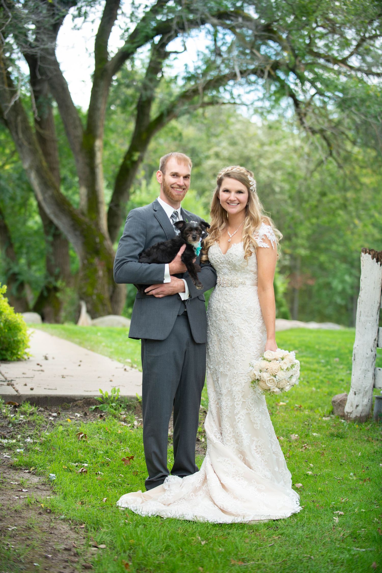 A couple poses for romantic wedding photos in a scenic garden with white fences. Rum River Barn Milaca Minnesota Weddings