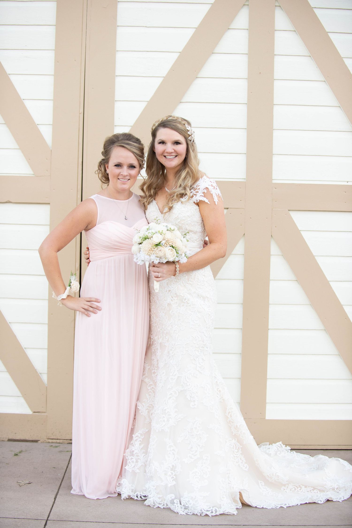 Two elegant dresses, one in white lace and one in blush pink, are showcased against a geometric backdrop. Milaca Minnesota Weddings
