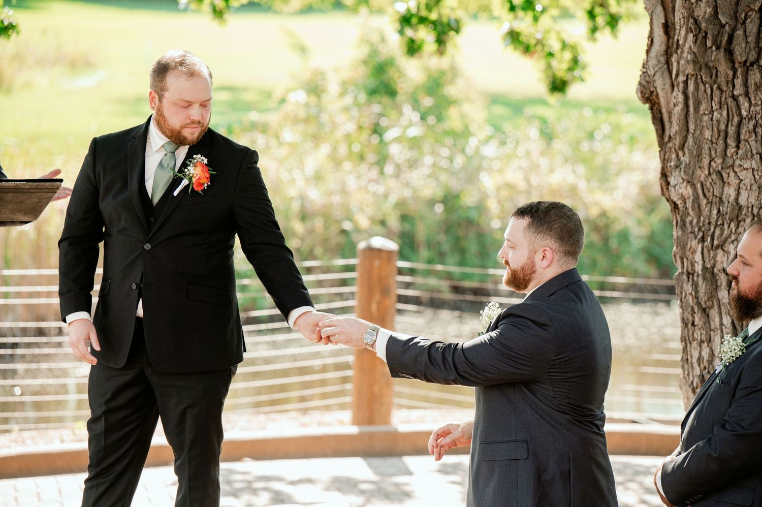 Wedding party members interact playfully during outdoor photo session.