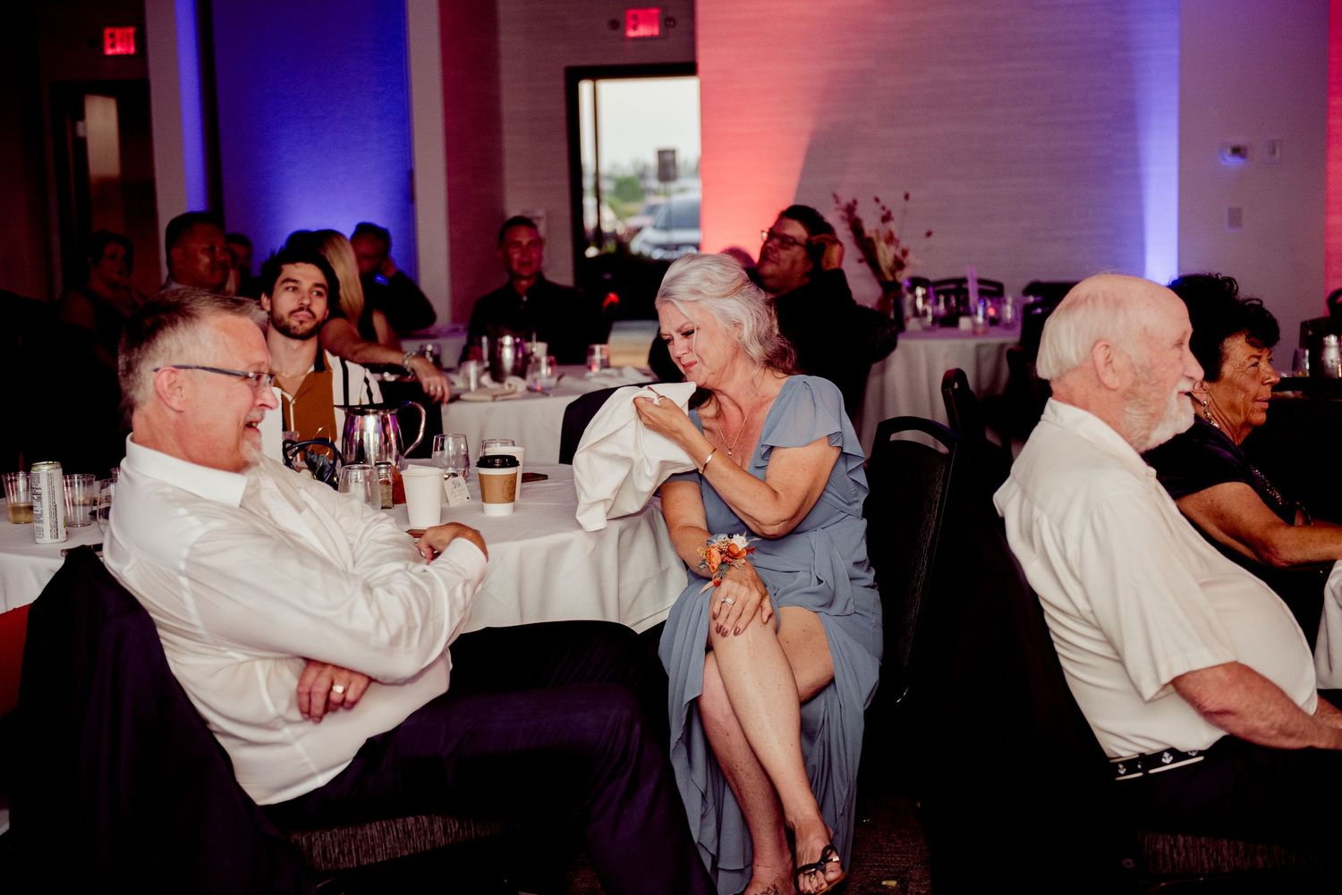 Pier B Duluth Wedding Wedding guests enjoying themselves at a reception with dramatic red and blue lighting.