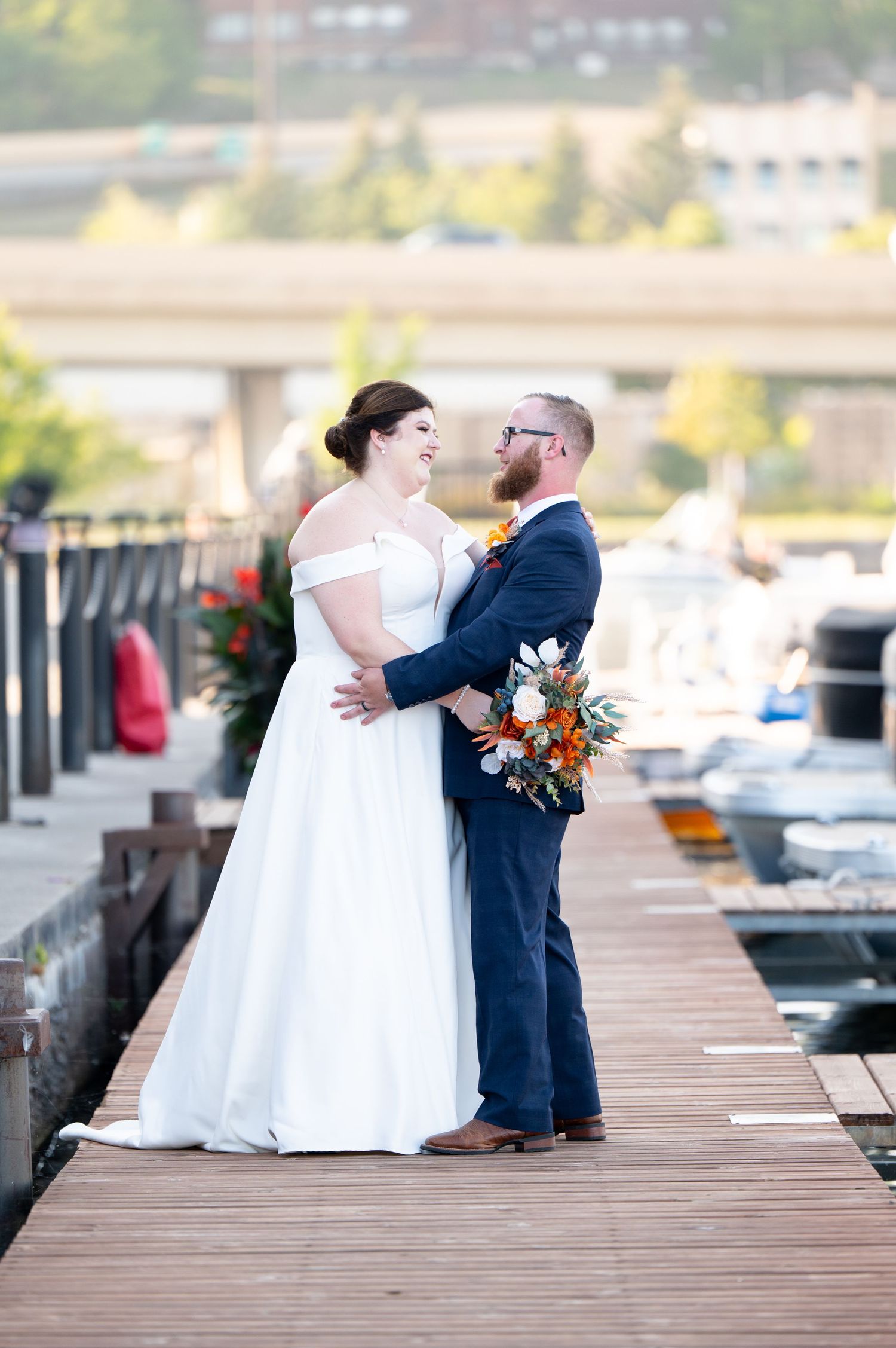 Pier B Duluth Wedding Wedding couple shares intimate moments during photo session on marina boardwalk.