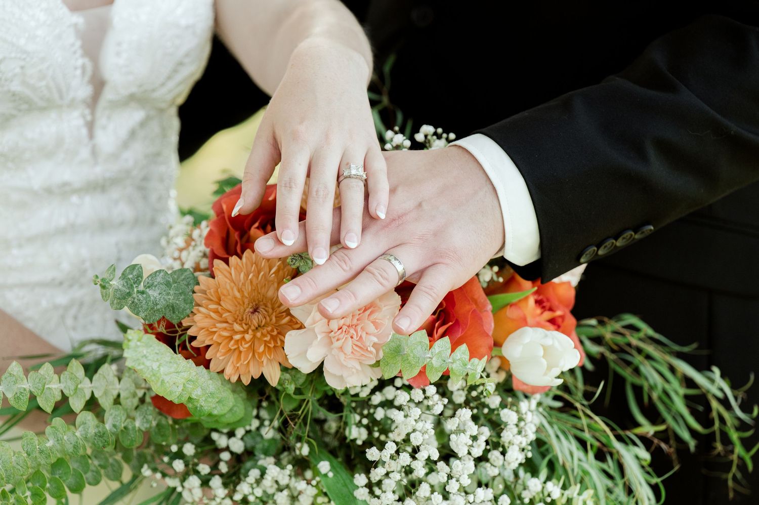 The Grands at Mulligans- Wedding Photos: detail shot of floral arrangement with orange dahlias and delicate white baby's breath.