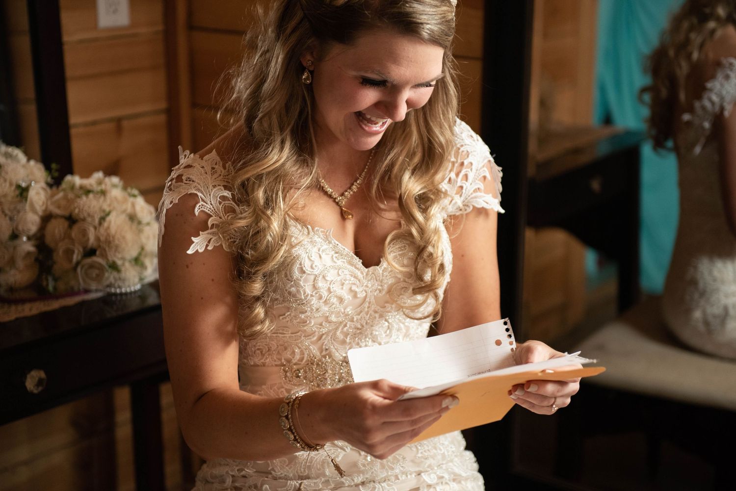 Someone in a lace wedding dress reads letters while sitting indoors. Rum River Barn Milaca Minnesota Weddings