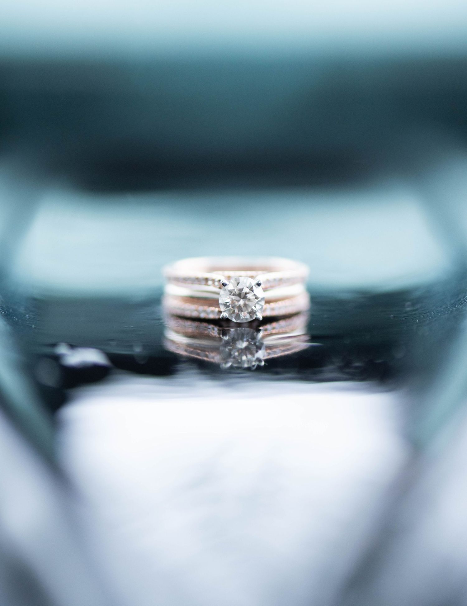 Diamond engagement ring shown in focus with similar rings blurred in background creating a bokeh effect.