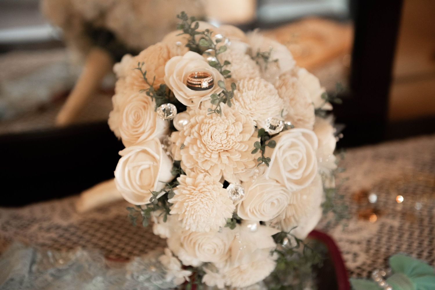 Elegant bridal bouquet featuring cream roses and peonies with silver eucalyptus sprigs.