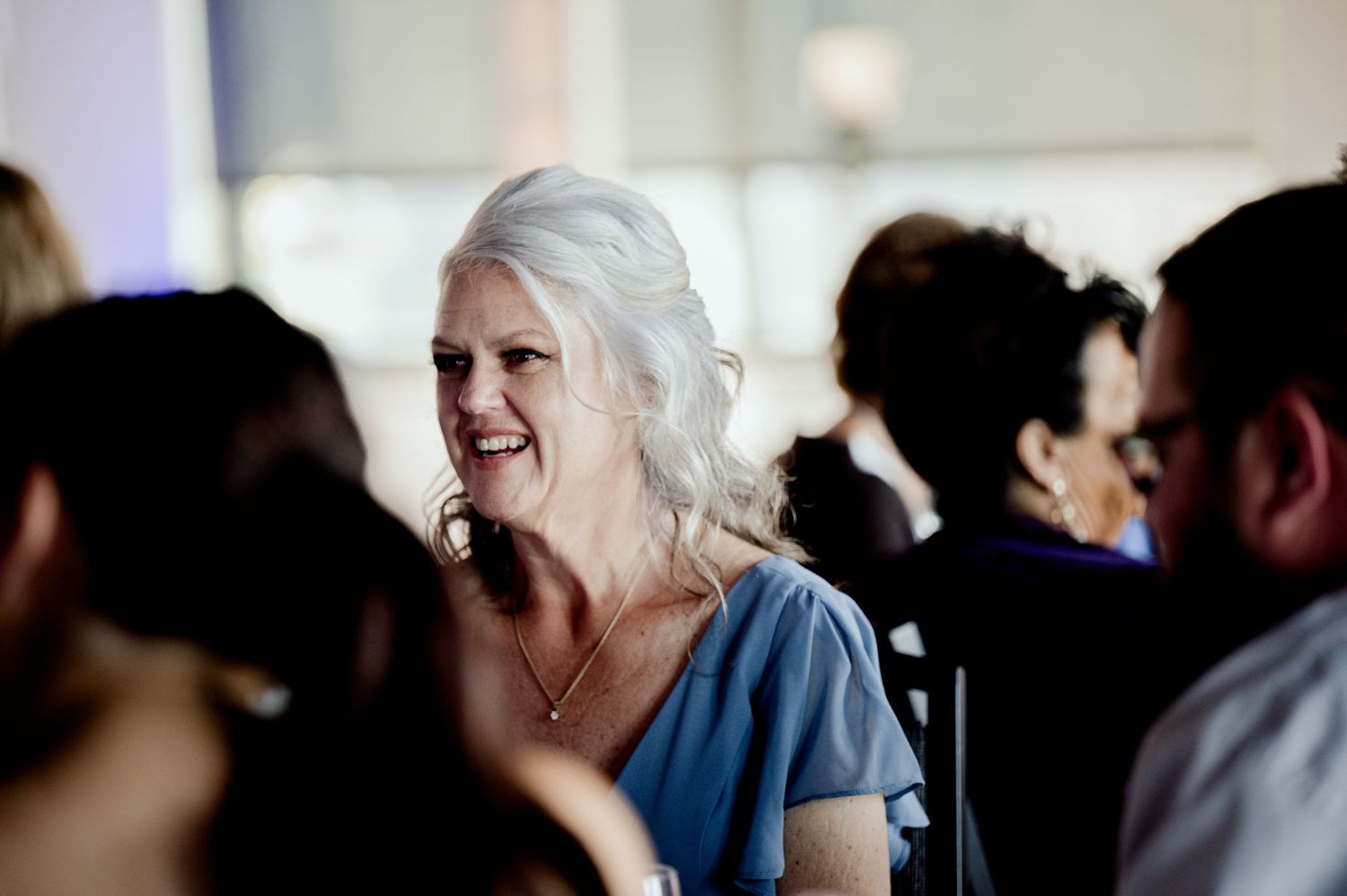 Pier B Duluth Wedding A candid wedding reception moment showing a joyful guest in blue attire.