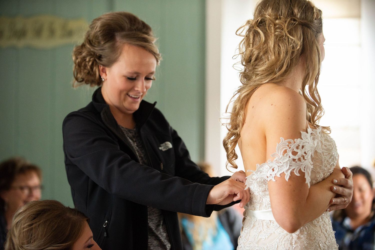 Final dress adjustments being made by stylist before wedding ceremony. Rum River Barn Milaca Minnesota Weddings