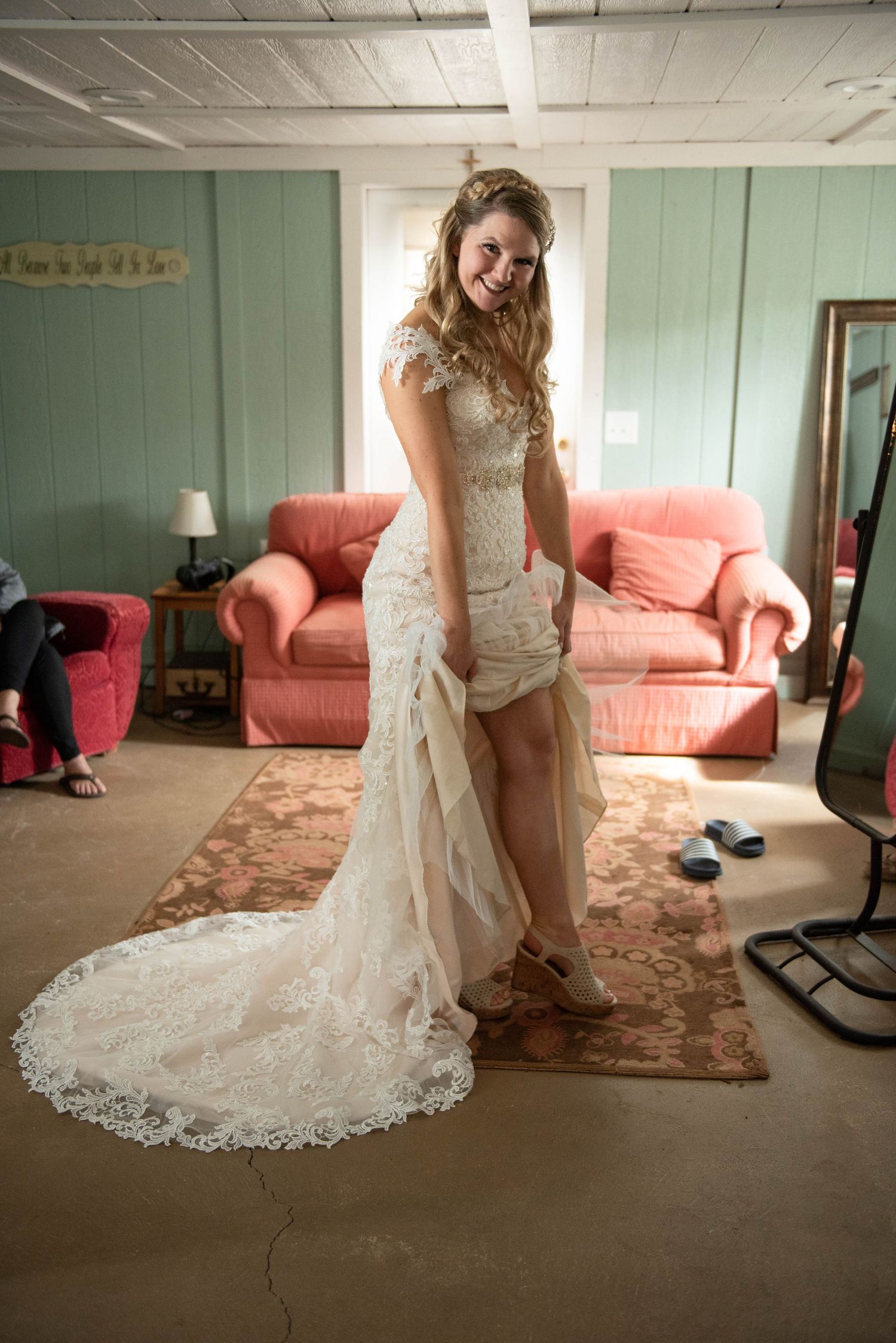 A wedding dress with lace details swirls gracefully in a room with pink furniture. Rum River Barn Milaca Minnesota Weddings