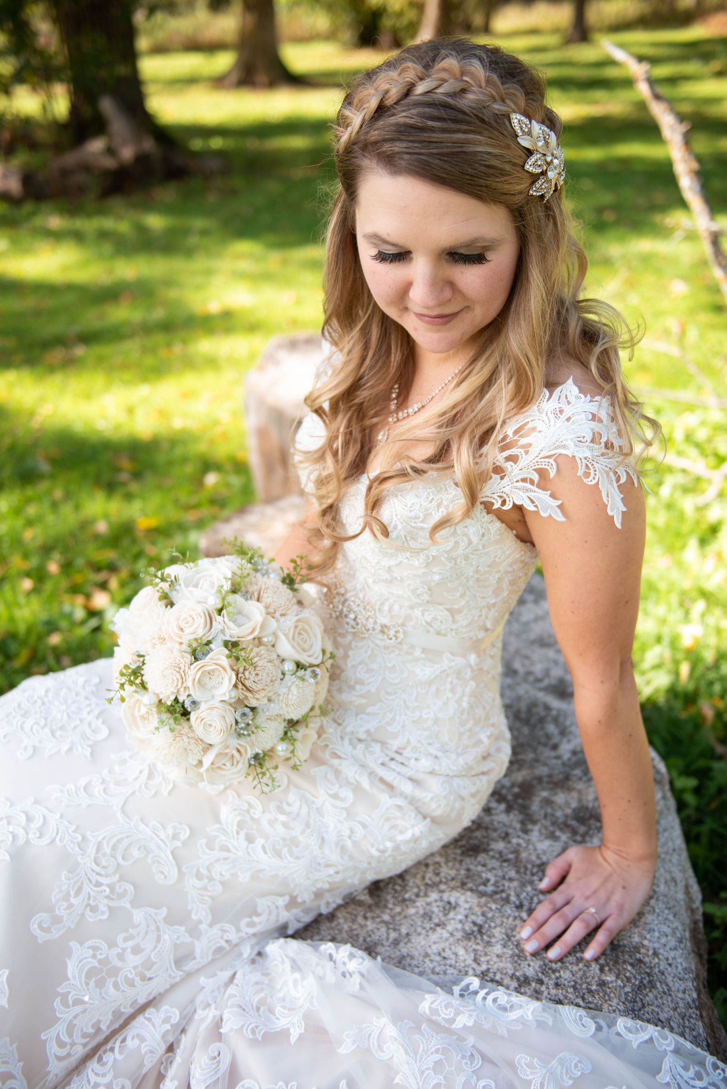 A beautiful lace wedding dress with delicate details is showcased in an outdoor garden setting. Rum River Barn Milaca Minnesota Weddings