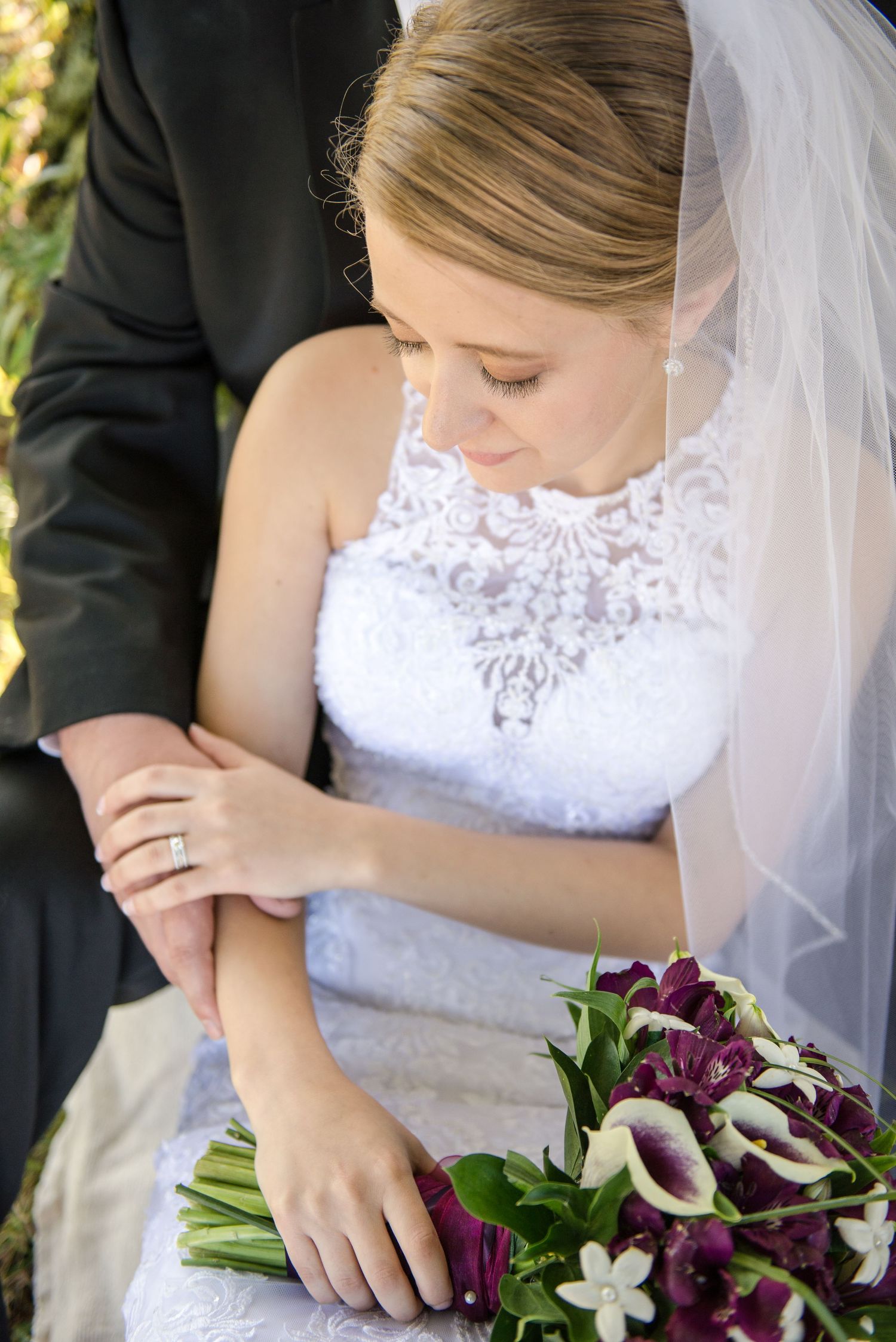 Beautiful wedding scene with a lace dress, veil and purple calla lily bouquet in sunlit garden. Andover wedding at Magestic Oaks Golf Club