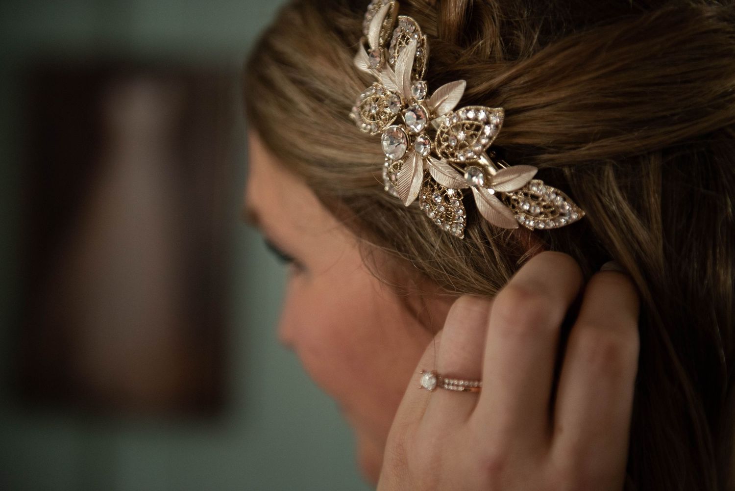 Sparkly crystal flower hair accessory detail shot with hand touching hair. Rum River Barn Milaca Minnesota Weddings