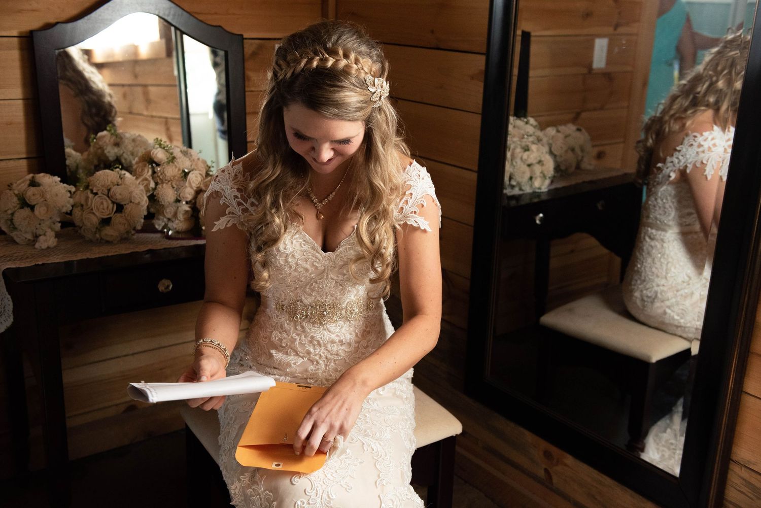 A joyful reaction while reading a letter in a wood-paneled room on wedding day. Rum River Barn Milaca Minnesota Weddings