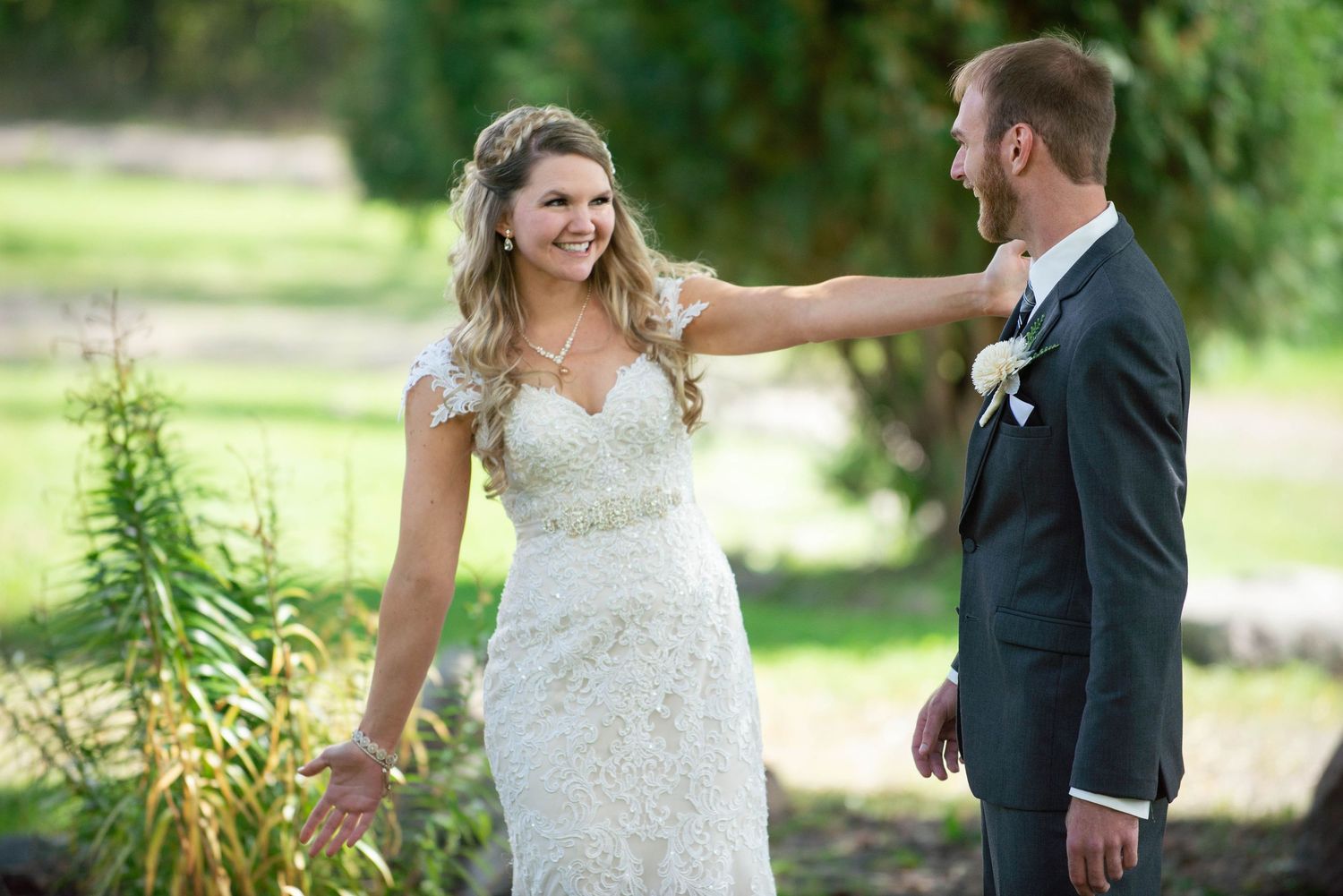 Playful first look moment between couple in wedding attire outdoors. Rum River Barn Milaca Minnesota Weddings