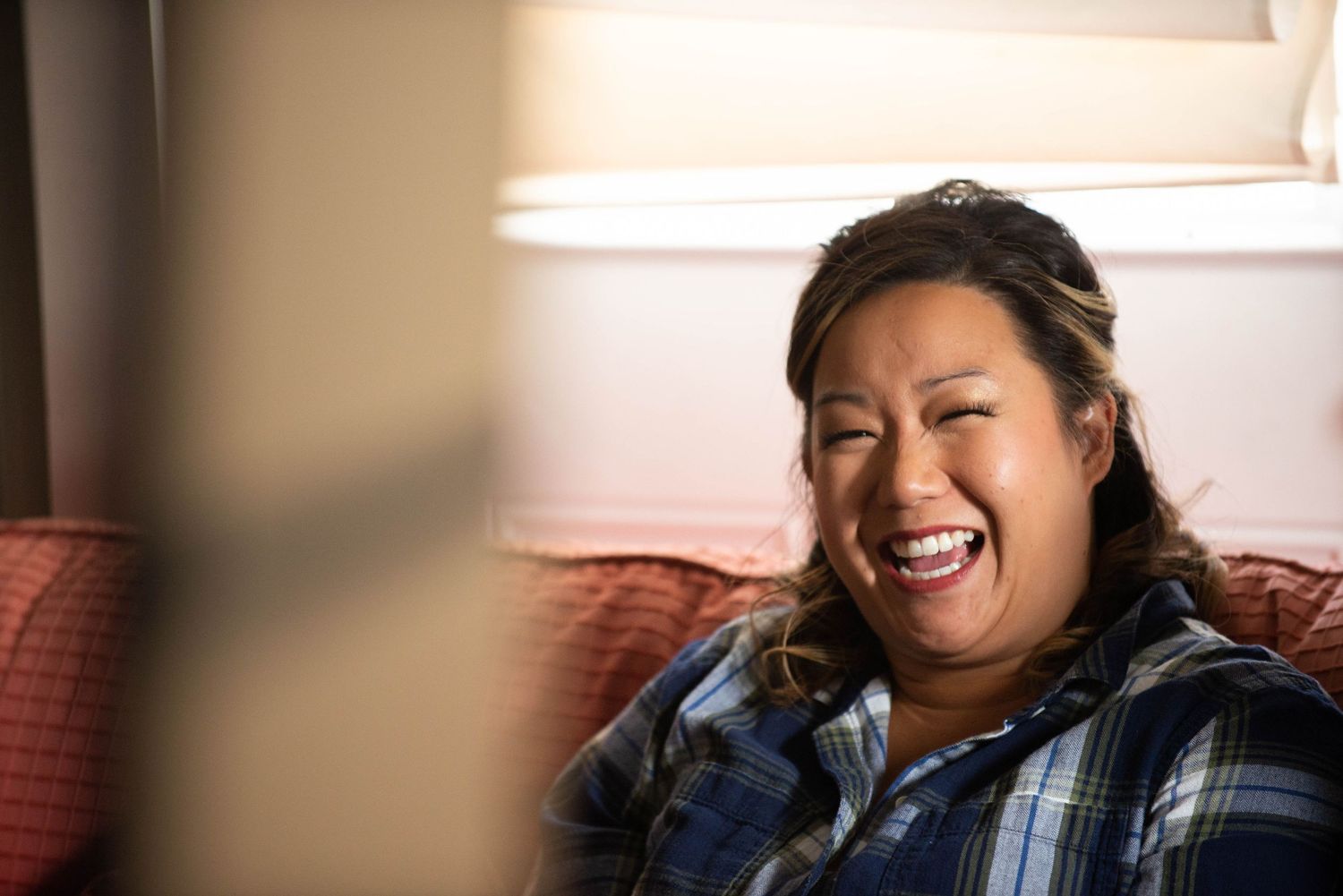 Candid moment of joyful laughter during a casual indoor gathering. Rum River Barn Milaca Minnesota Weddings
