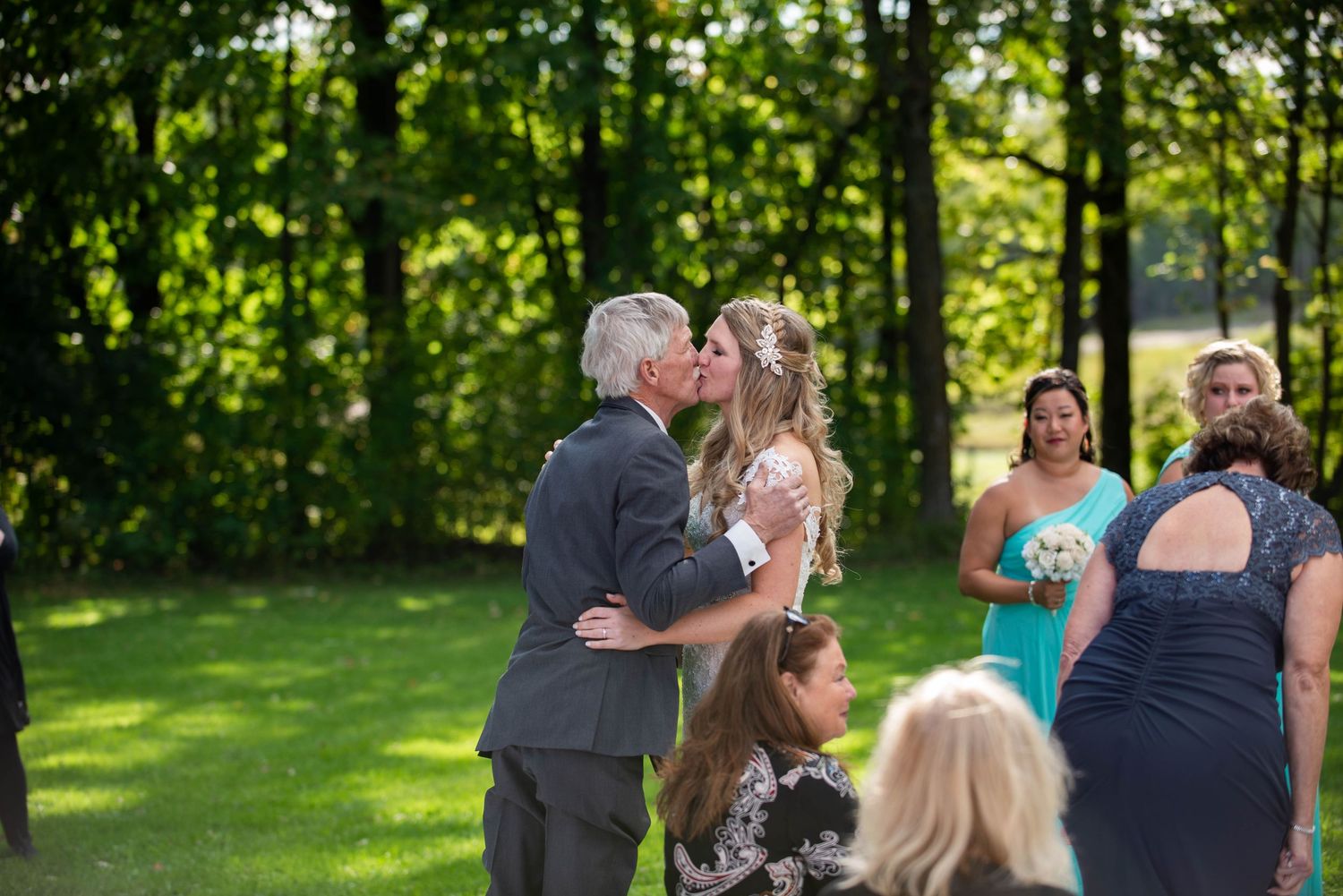 A wedding ceremony moment captured in a sunlit garden setting. Rum River Barn Milaca Minnesota Weddings