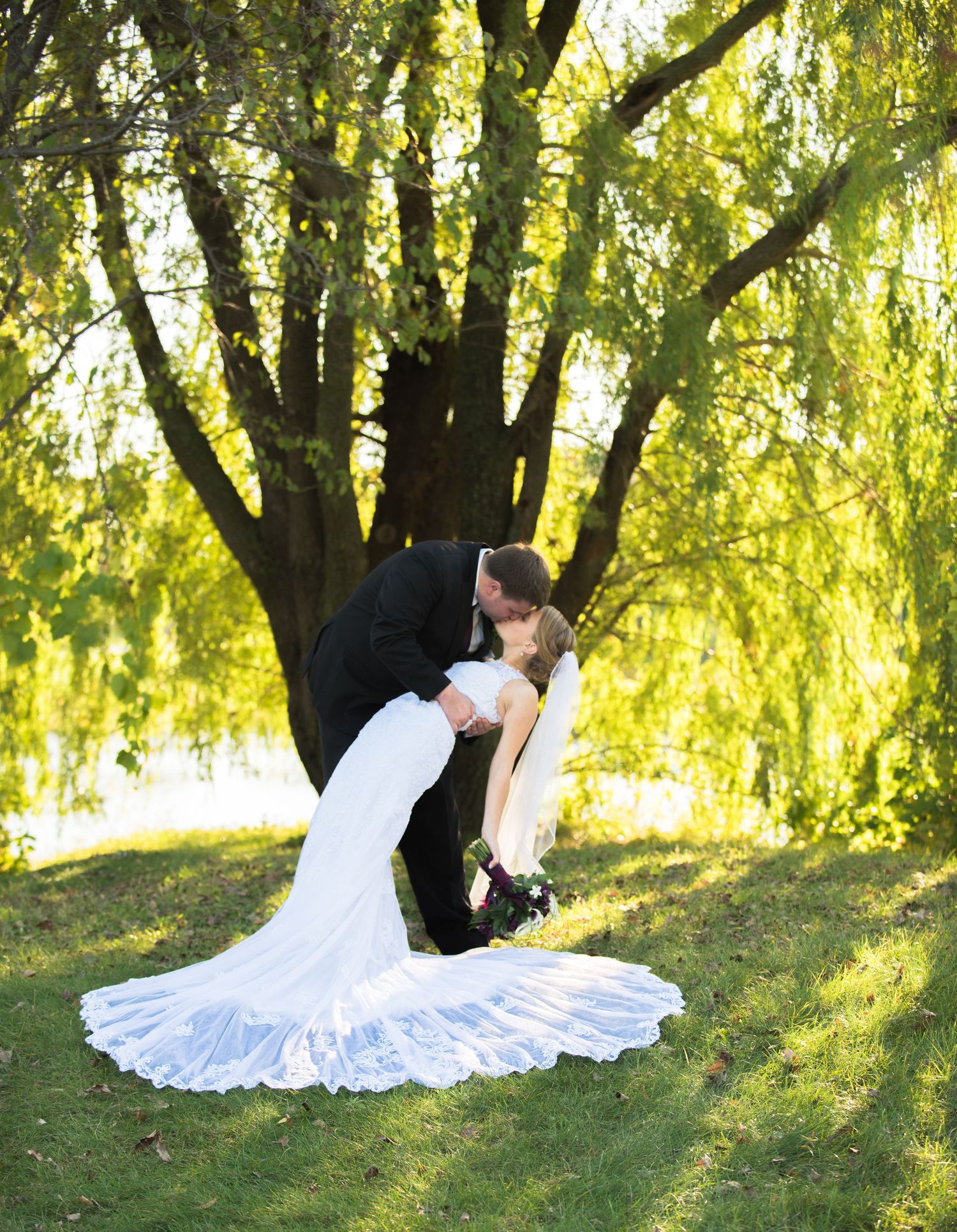 Elegant wedding dance dip pose under weeping willow trees in golden afternoon light. Andover wedding at Magestic Oaks Golf Club