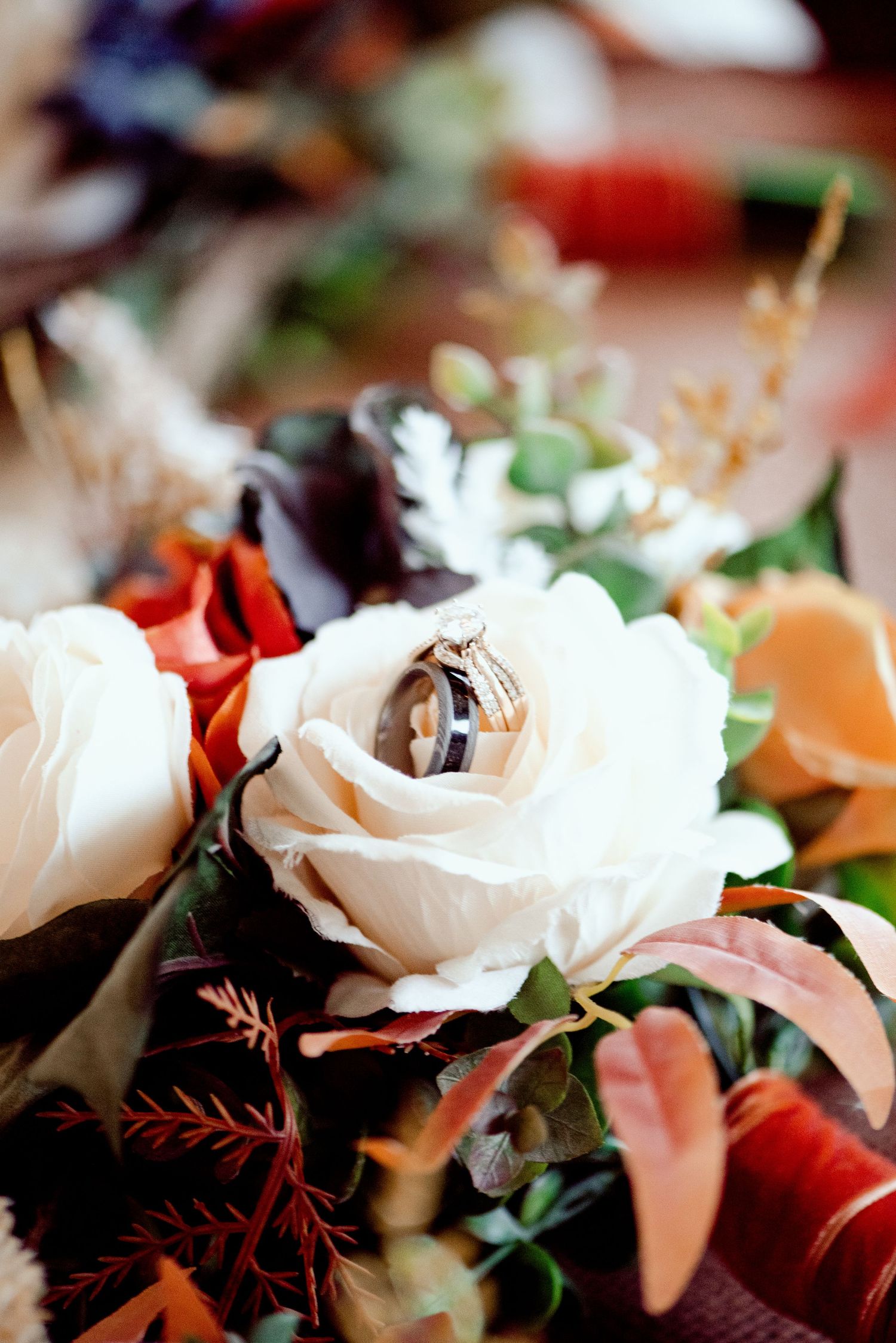Pier B Duluth Wedding Wedding rings beautifully displayed inside a white rose among colorful floral arrangements.