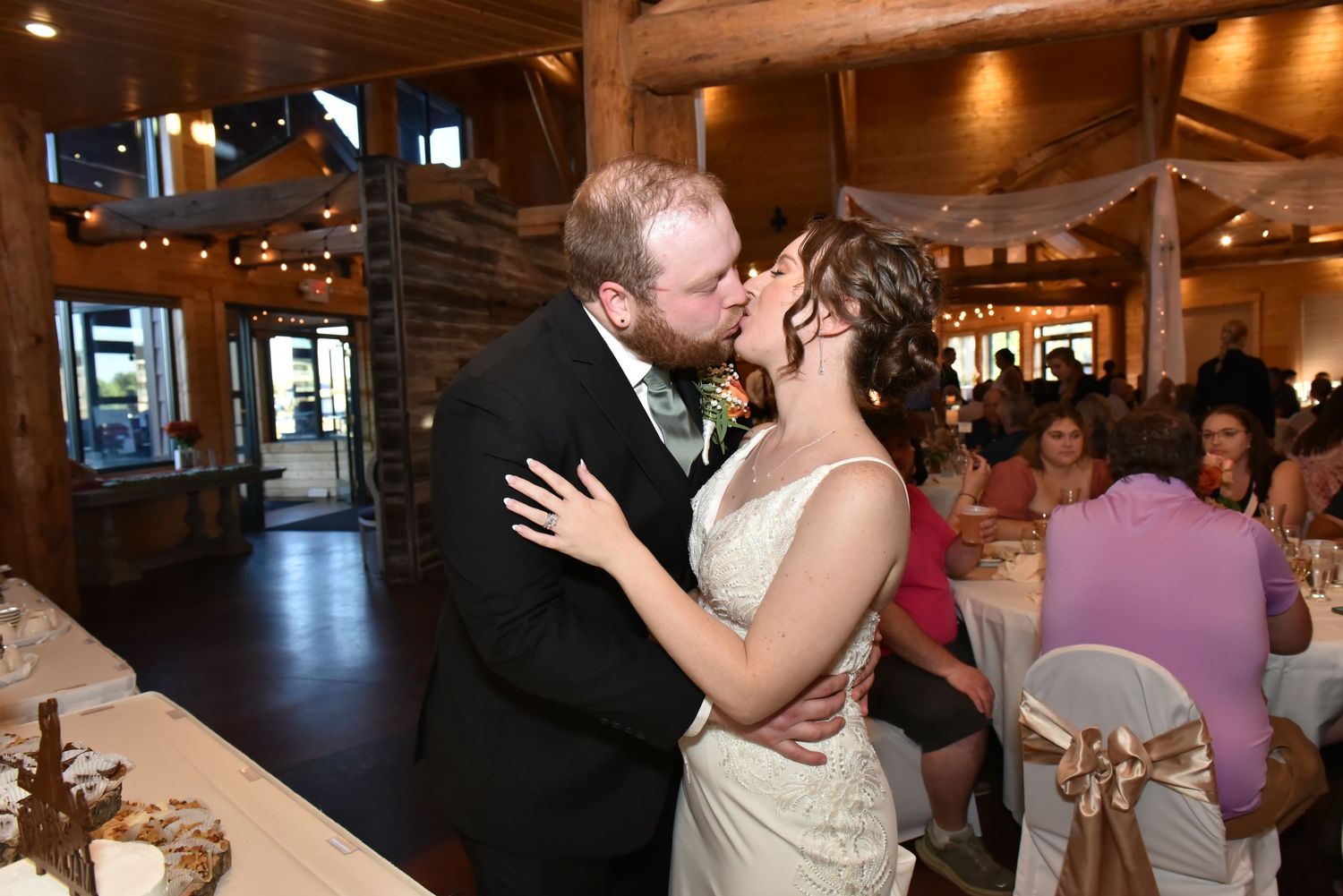 The Grands at Mulligans- Wedding Photos: reception celebration inside rustic wooden barn venue with warm lighting.