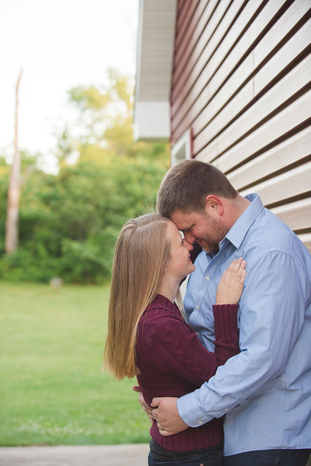Four sequential photos showing an intimate moment between a couple against a white building exterior.