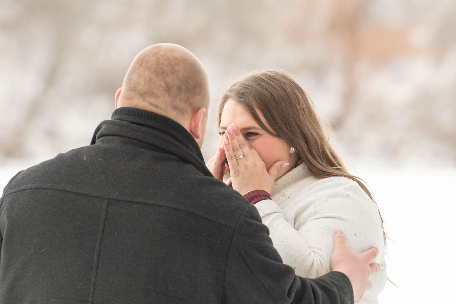 Couple sharing tender moments outdoors during their winter engagement session.