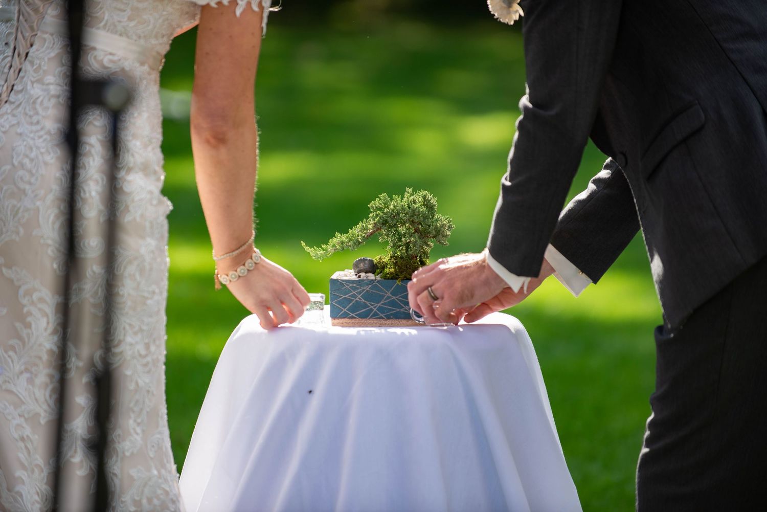 Close-up shot of ceremonial planting during an outdoor wedding ceremony. Rum River Barn Milaca Minnesota Weddings