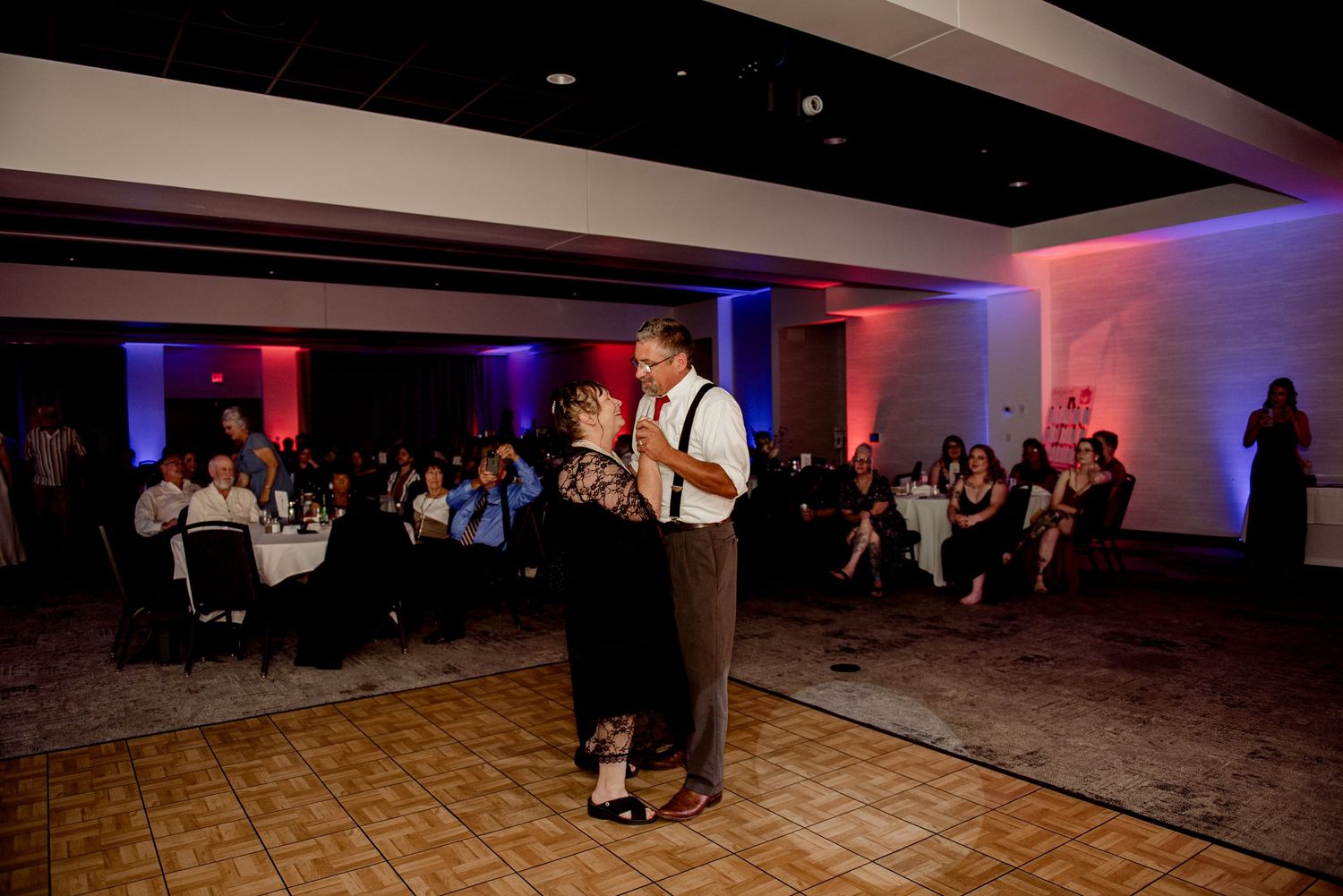 Pier B Duluth Wedding A dance floor moment at a wedding reception with blue and red ambient lighting.