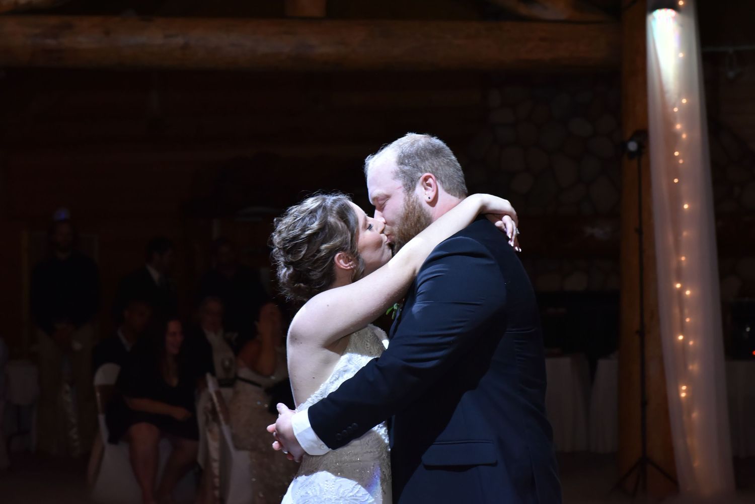 The Grands at Mulligans- Wedding Photos: Couple shares romantic first dance in dimly lit barn reception venue.