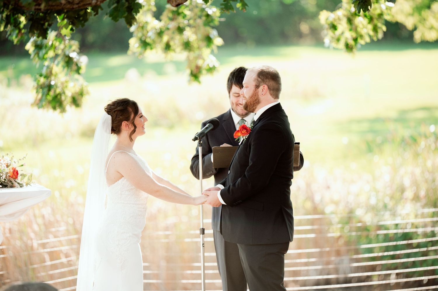 The Grands At Mulligans. A wedding ceremony takes place on a beautiful deck overlooking a pond.